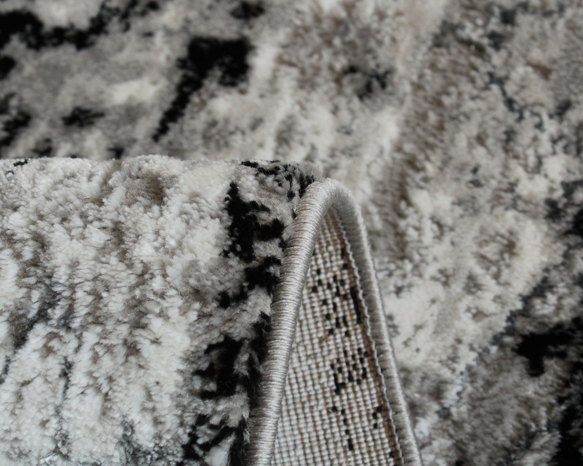 Tapete cinza, preto e branco com textura felpuda e padrão abstrato