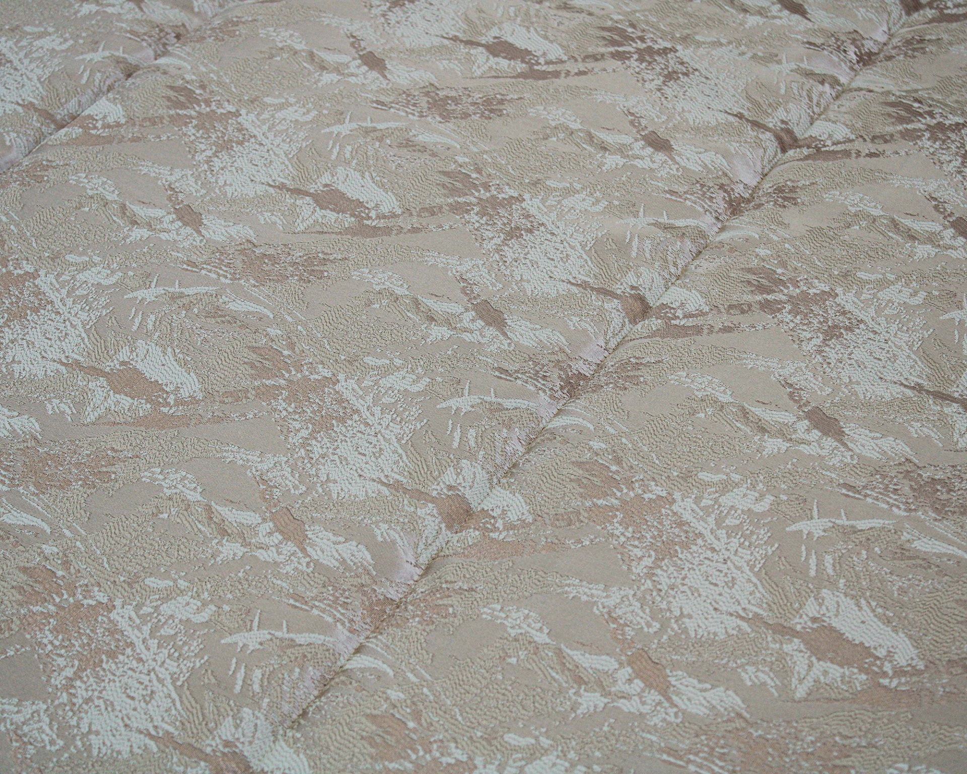 Colchão com tecido estampado e textura matelassê em tons bege e castanho