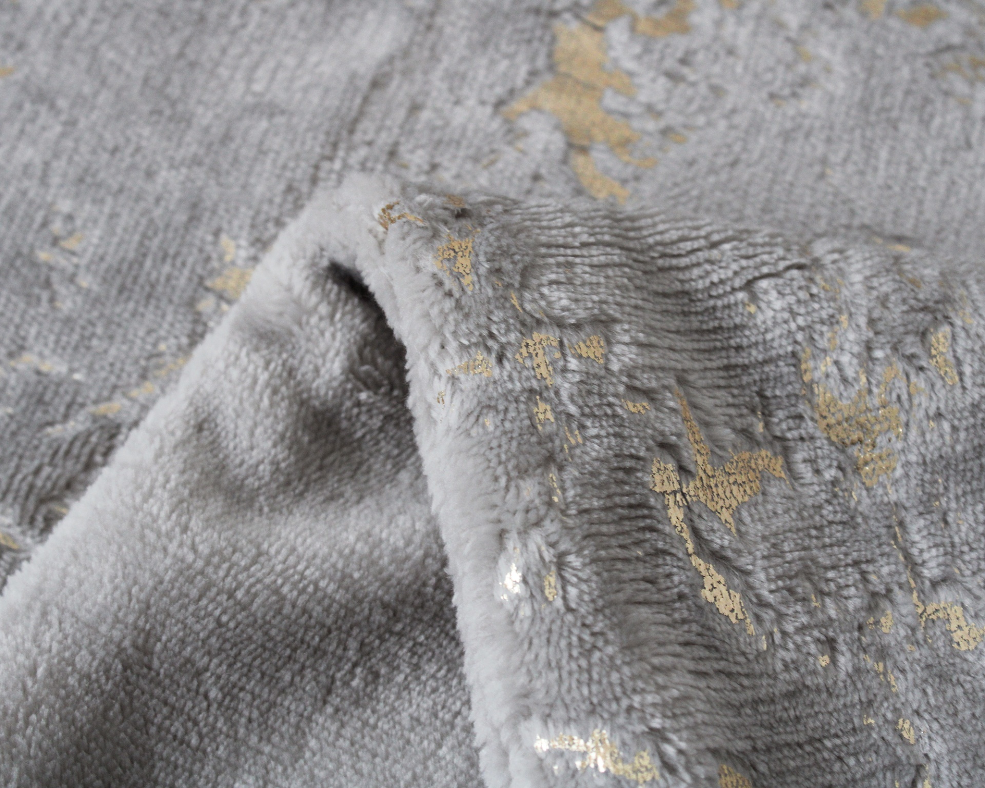 Tecido cinzento felpudo com padrão dourado brilhante