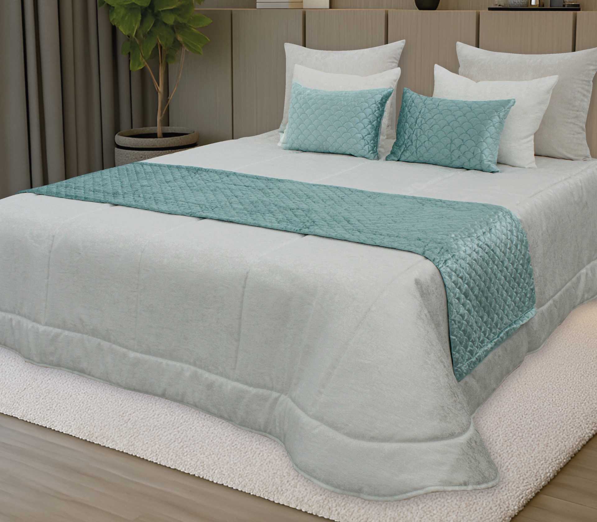 Cama com edredão cinza claro e detalhes azuis, almofadas brancas, tapete creme e planta ao lado