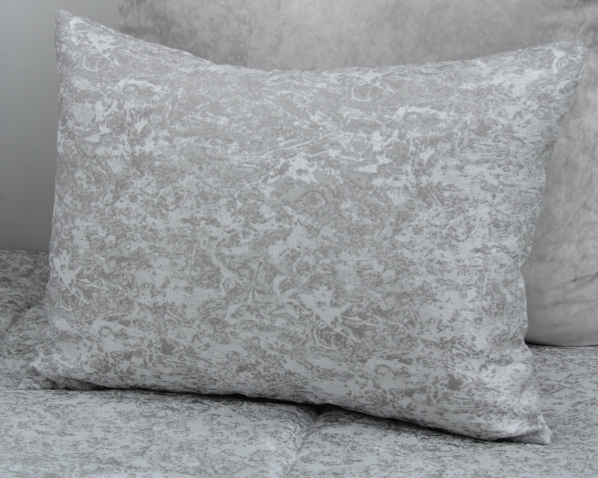 Travesseiro cinza claro com padrão floral texturizado