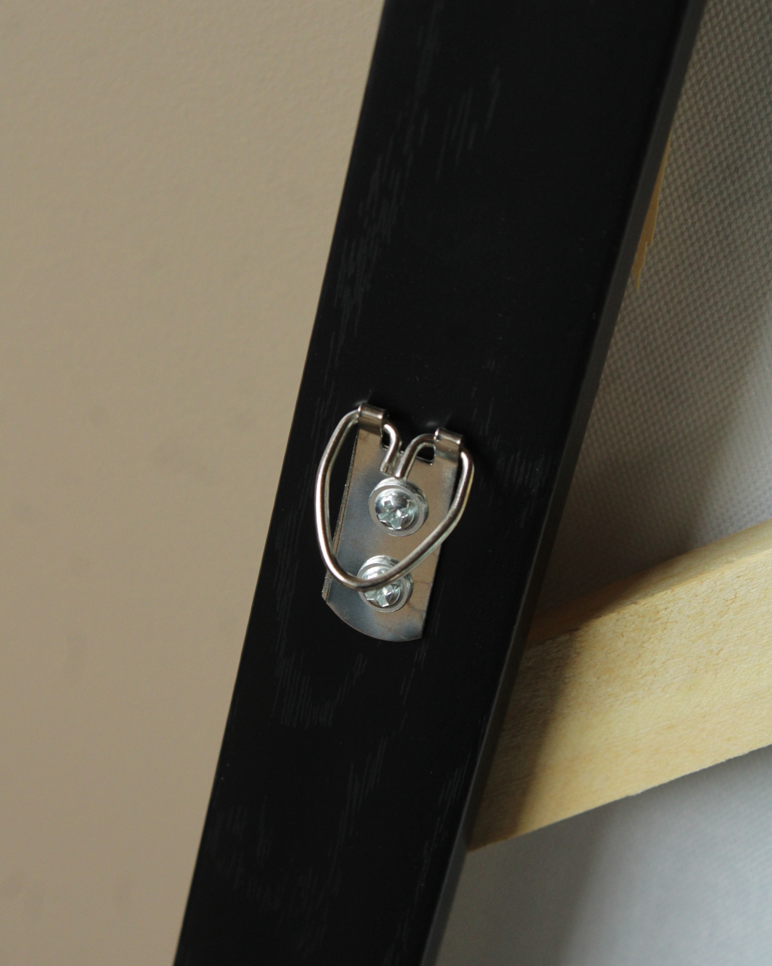 Suporte metálico em moldura preta com madeira e tela branca