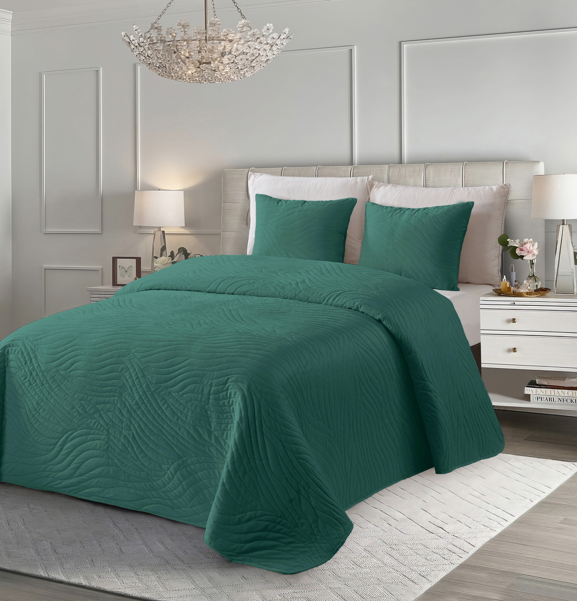 Colcha verde escura texturada num quarto moderno com cabeceira creme e candeeiros.