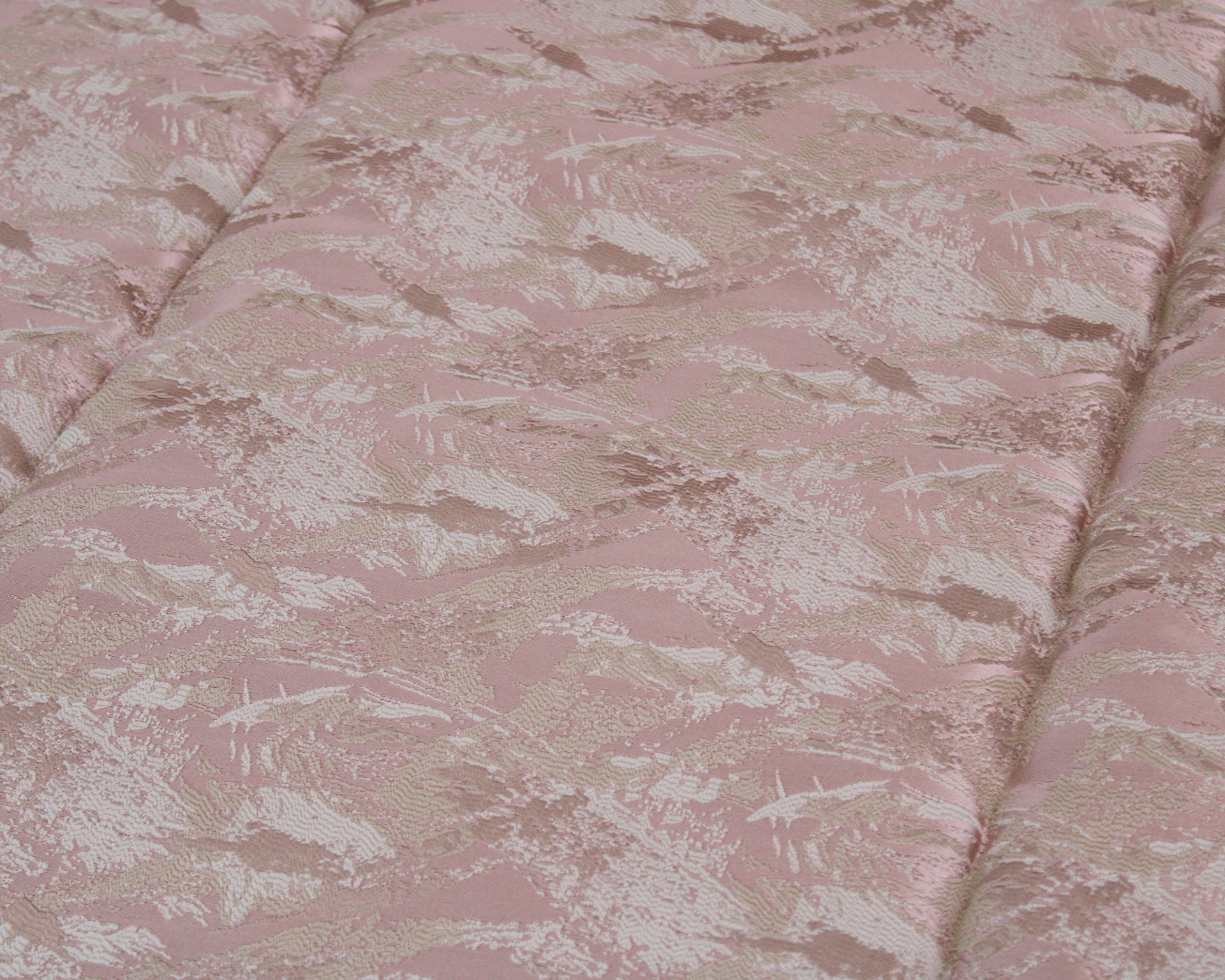 Colchão ou almofada rosa com padrão texturado em tons de bege e branco