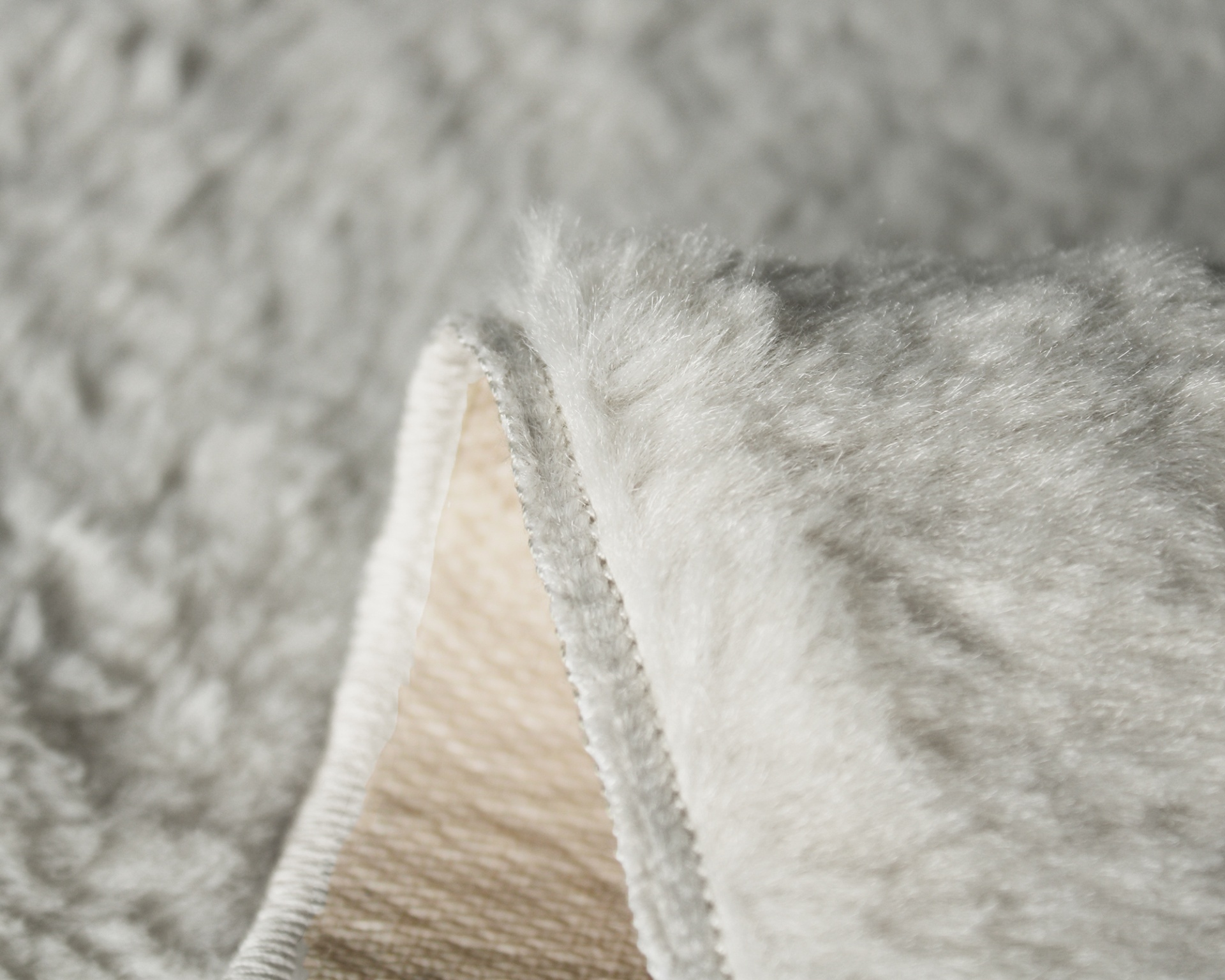 Cobertor felpudo creme claro com costura visível na beira