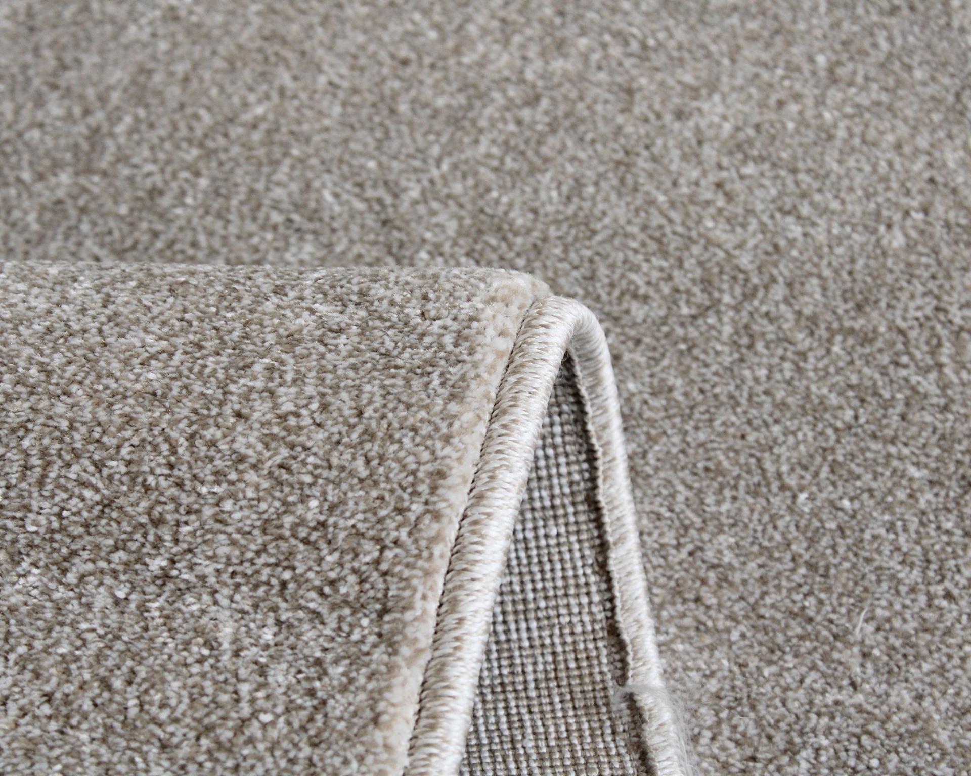 Tapete bege de tecido sintético com bordas costuradas