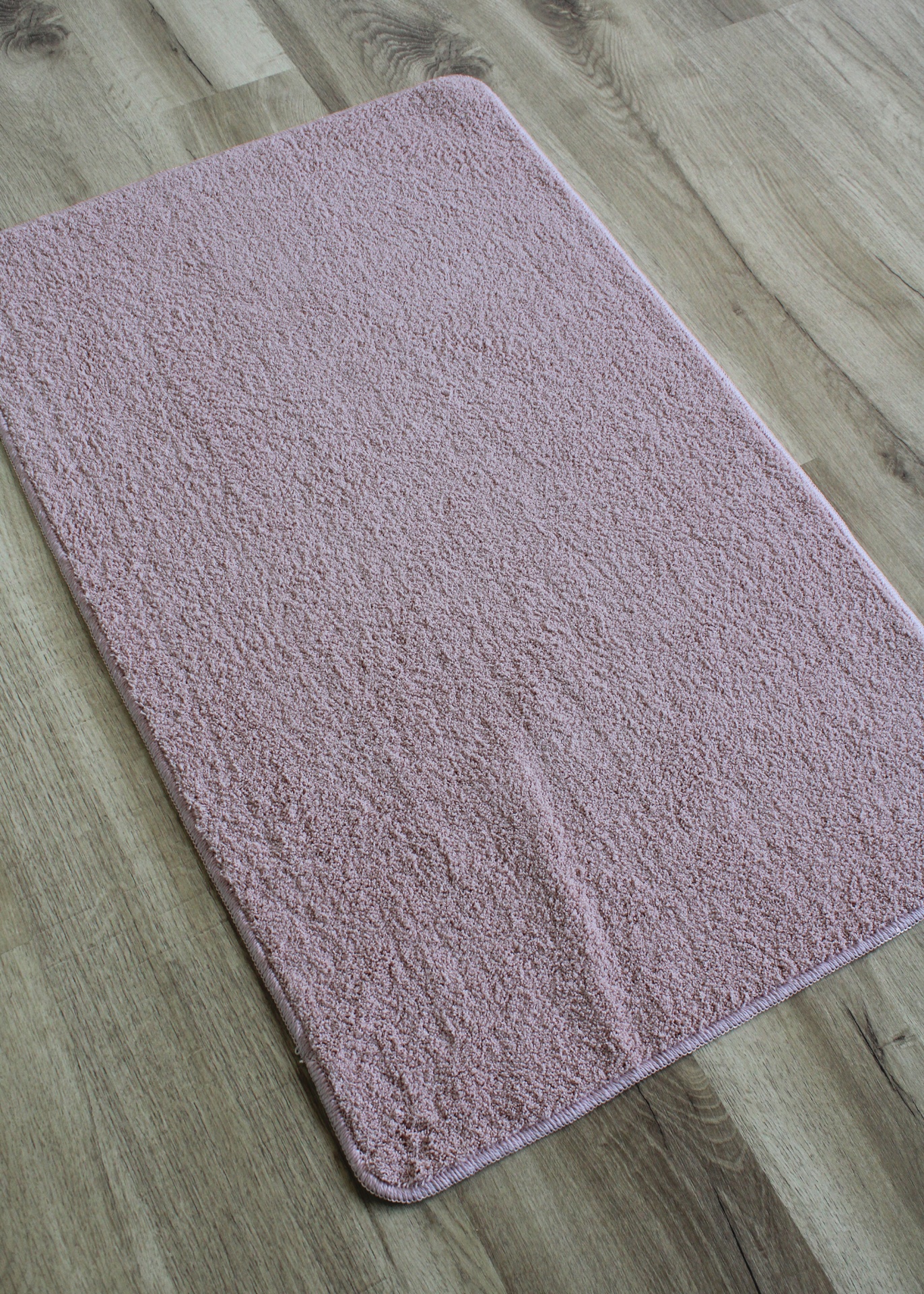 Tapete rosa claro felpudo em chão de madeira clara