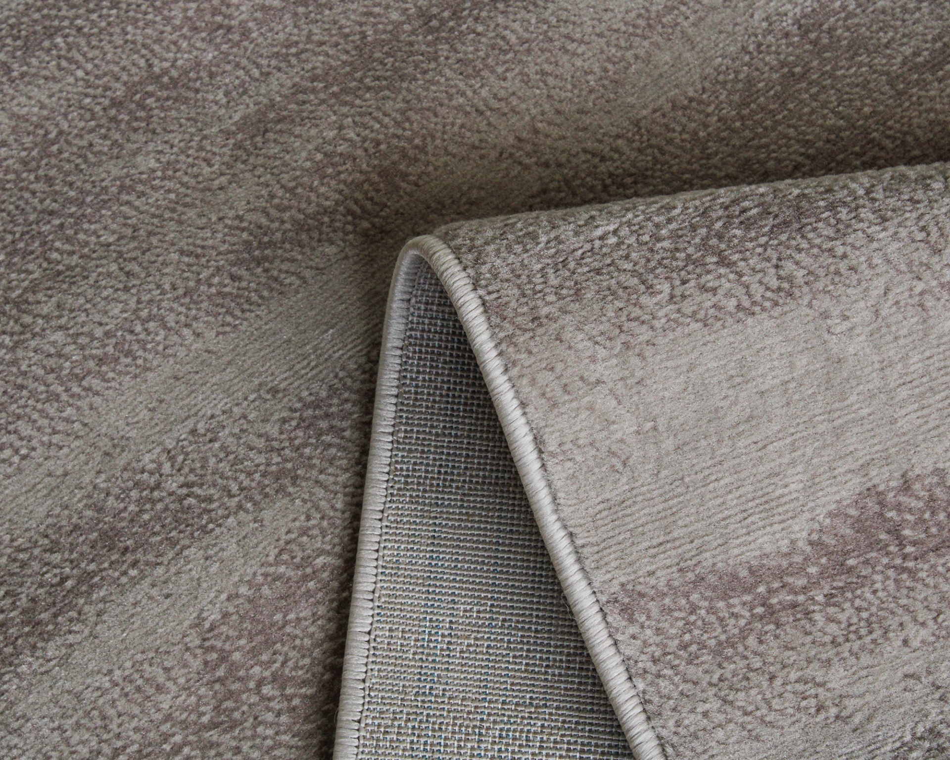 Tapete bege com padrão subtil e dobra mostrando o verso