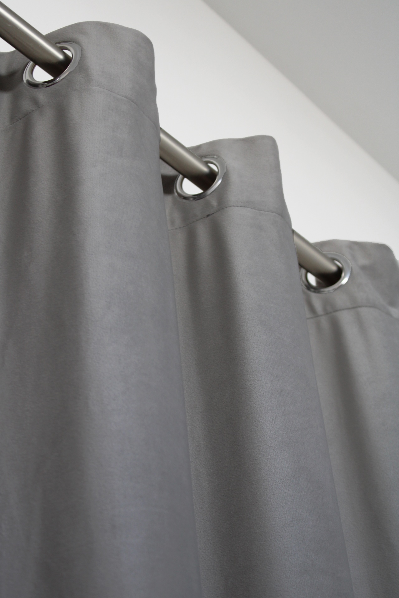 Cortina cinzenta com ilhóses metálicos e varão prateado