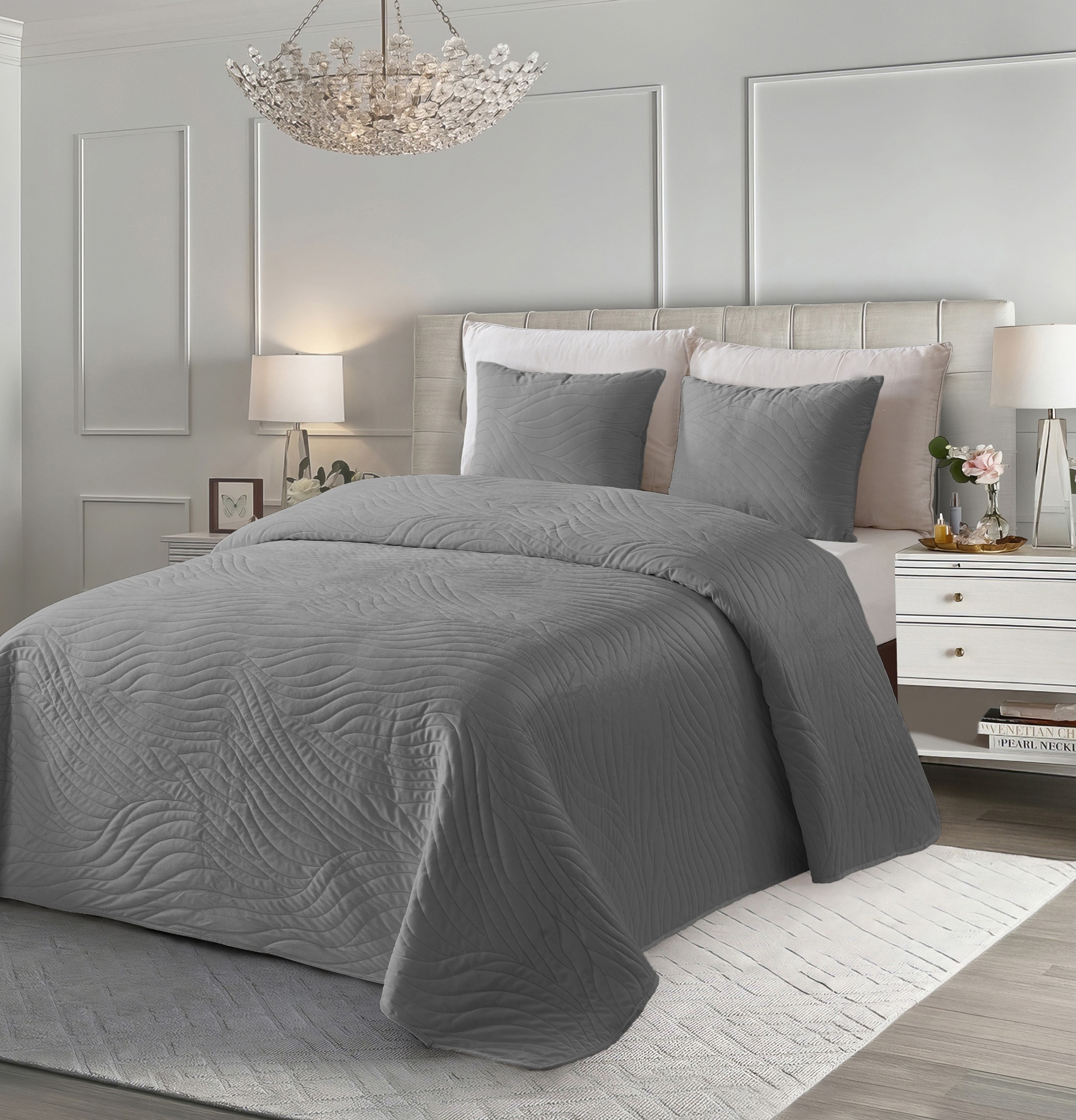 Cama com conjunto de cama cinzento texturizado num quarto neutro