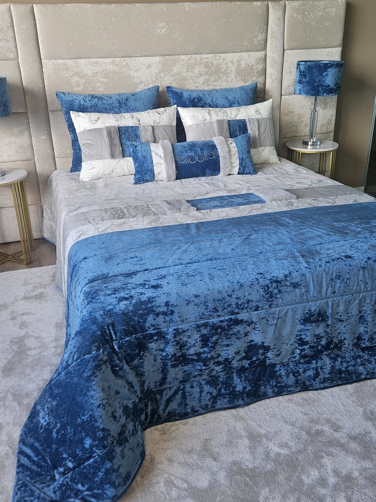 Edredão em Veludo Ref: Nepal Azul Colcha e almofadas azuis e cinza em cama com cabeceira estofada e mesas de cabeceira