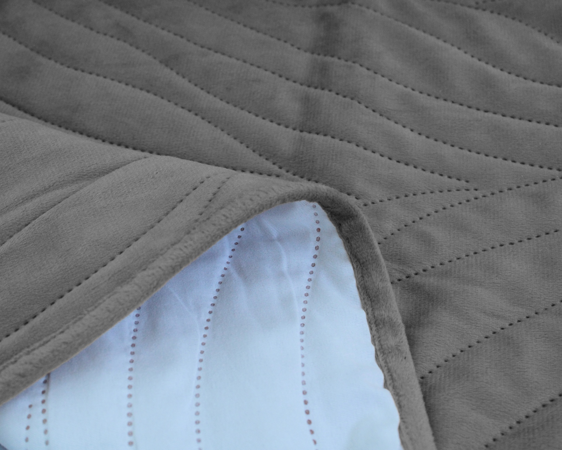 Cobertor cinzento com padrão ondulado e parte inferior branca