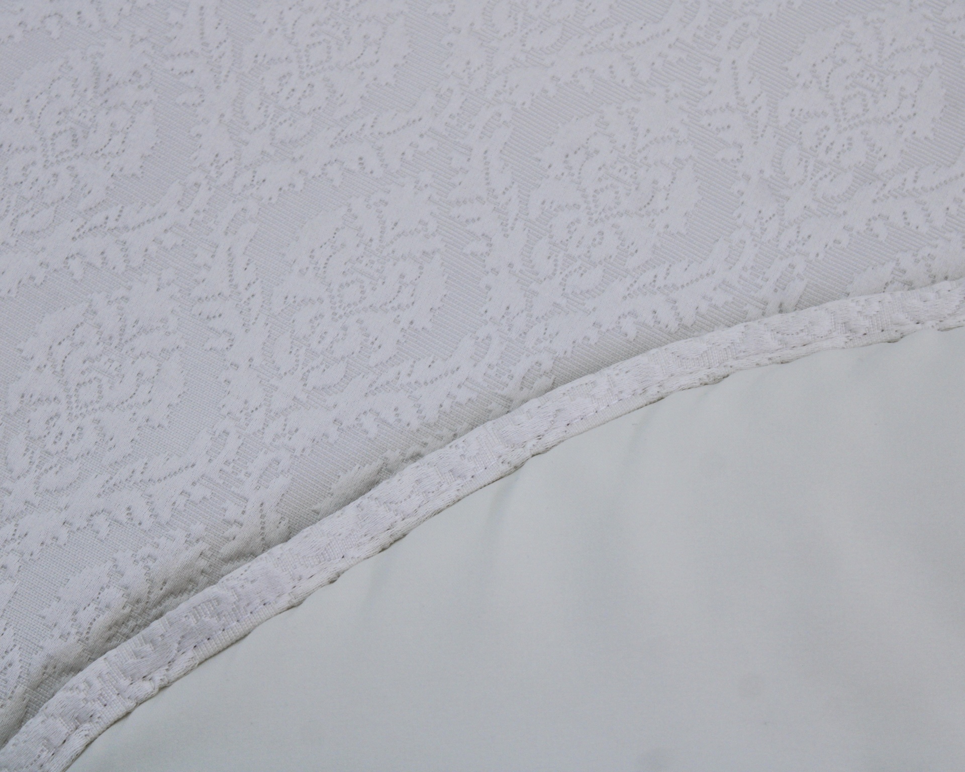 Tecido branco com padrão floral e textura lisa com costura branca