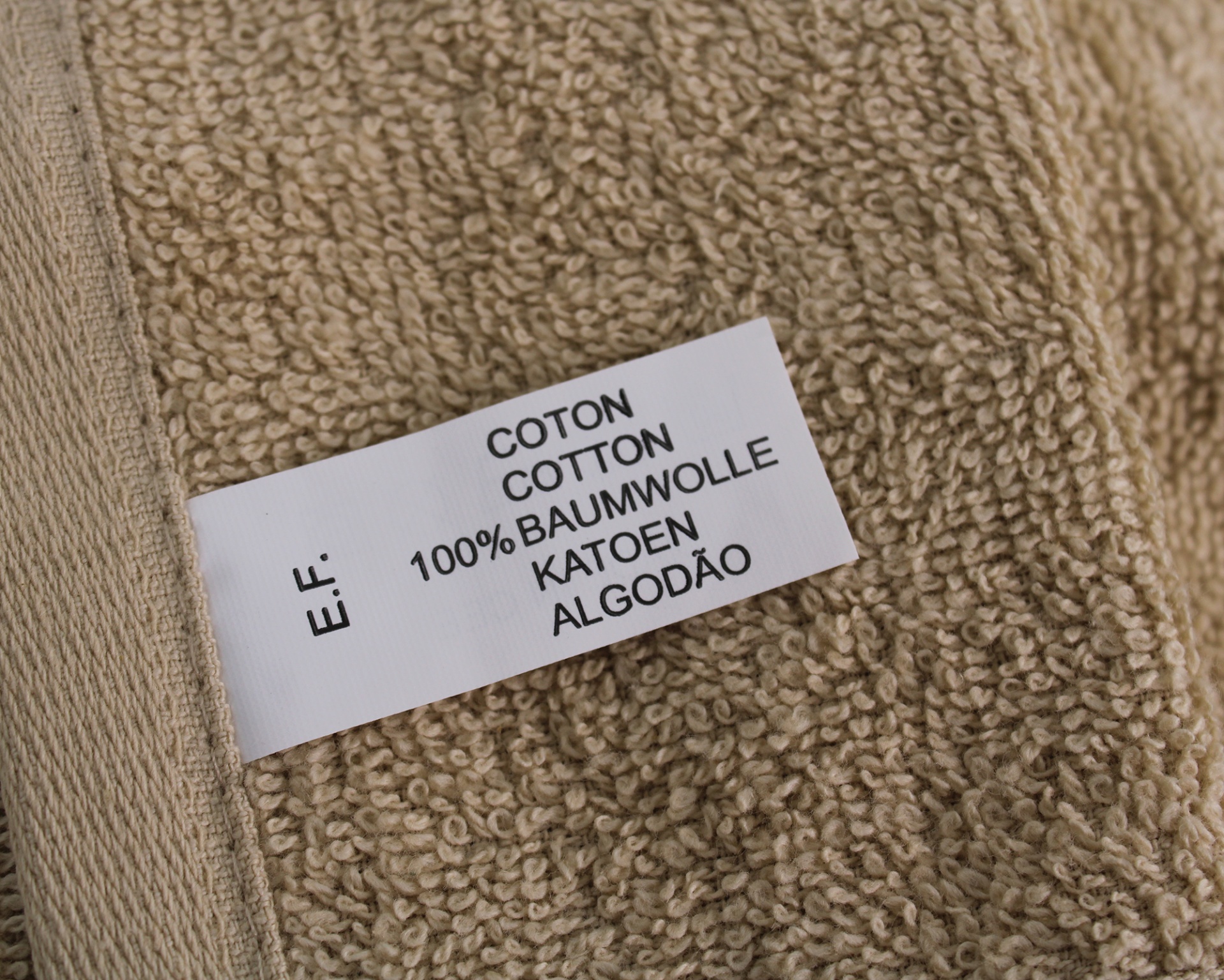 Etiqueta de composição de tecido sobre toalha castanho claro
