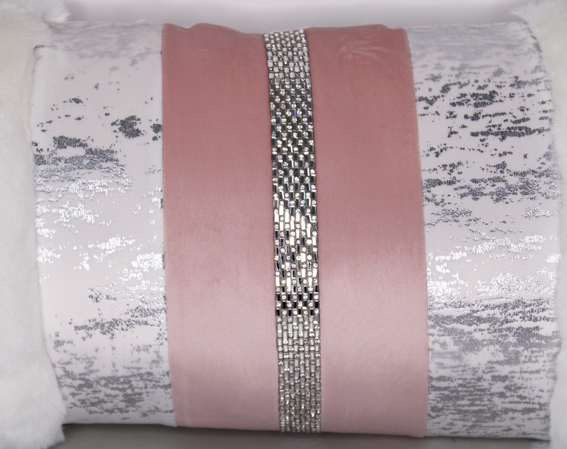 Três almofadas decorativas empilhadas com cores branco, rosa e prata