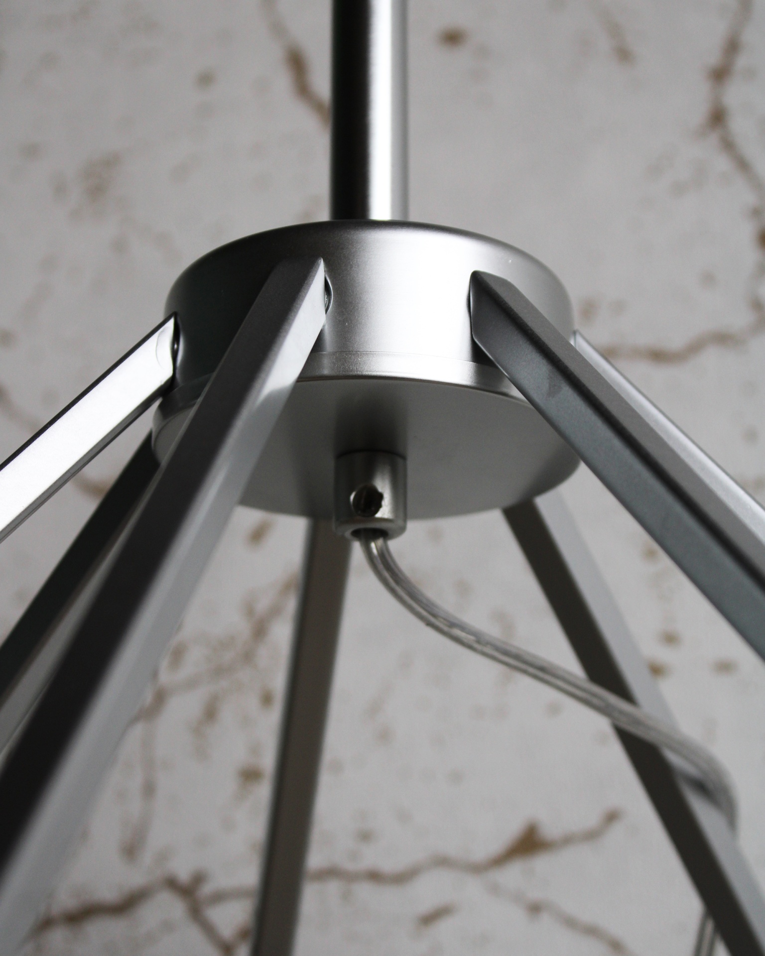 Luminária de teto em metal prateado com hastes triangulares e cabo transparente