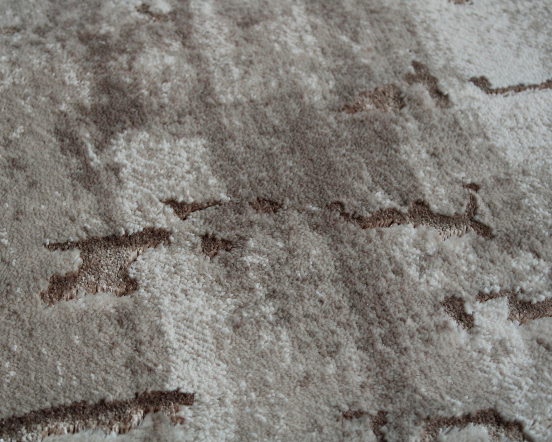 Tapete felpudo bege com padrão abstrato castanho e branco