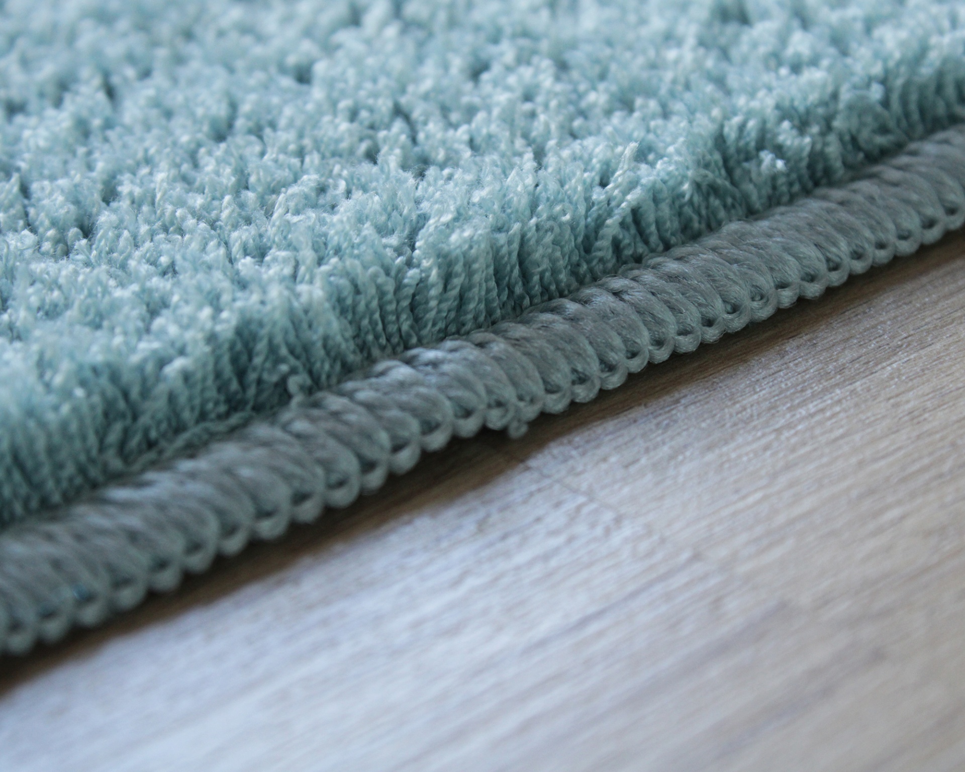 Tapete de textura esponjosa azul claro com borda rematada