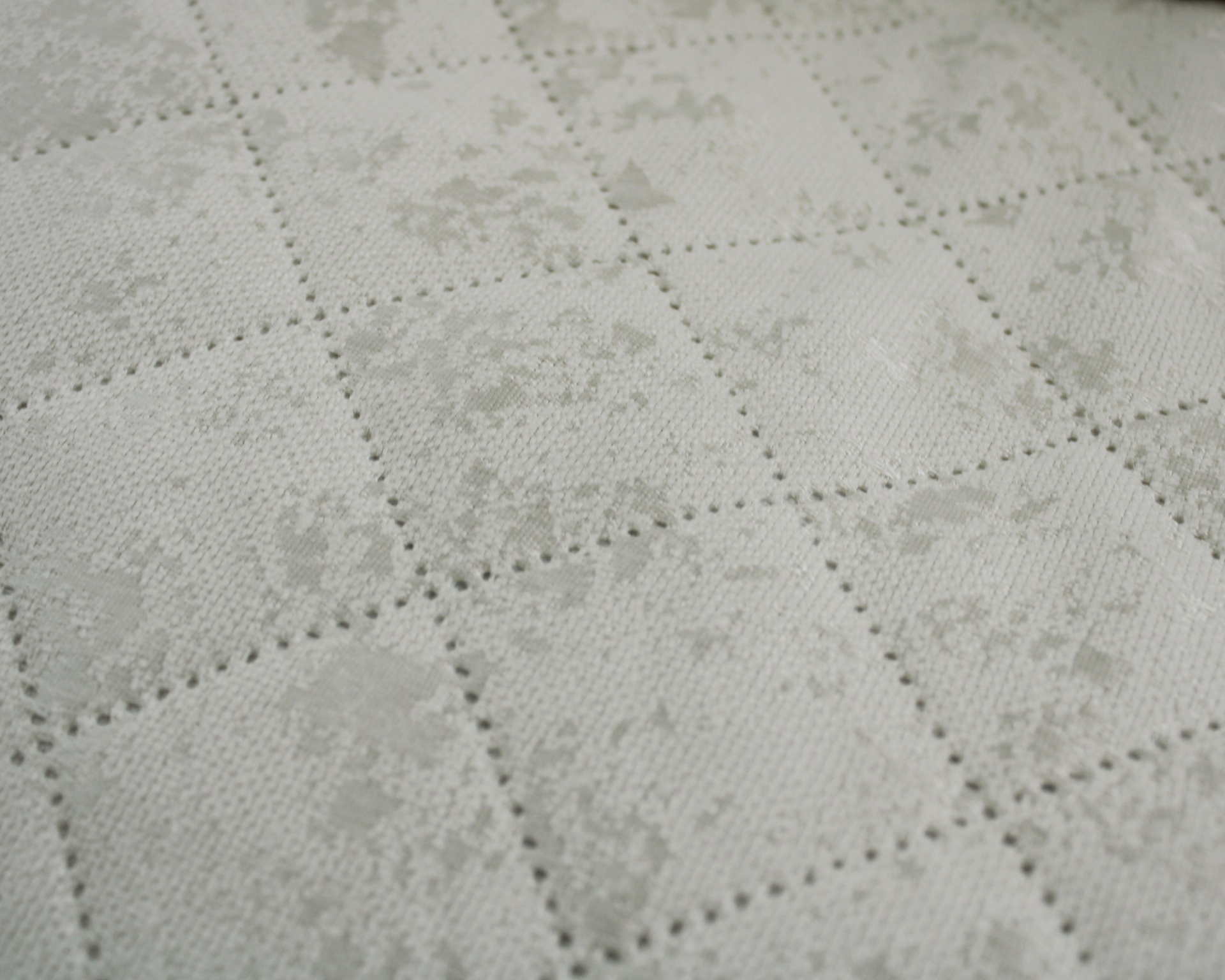Tecido branco com padrão em relevo de quadrados e pontos