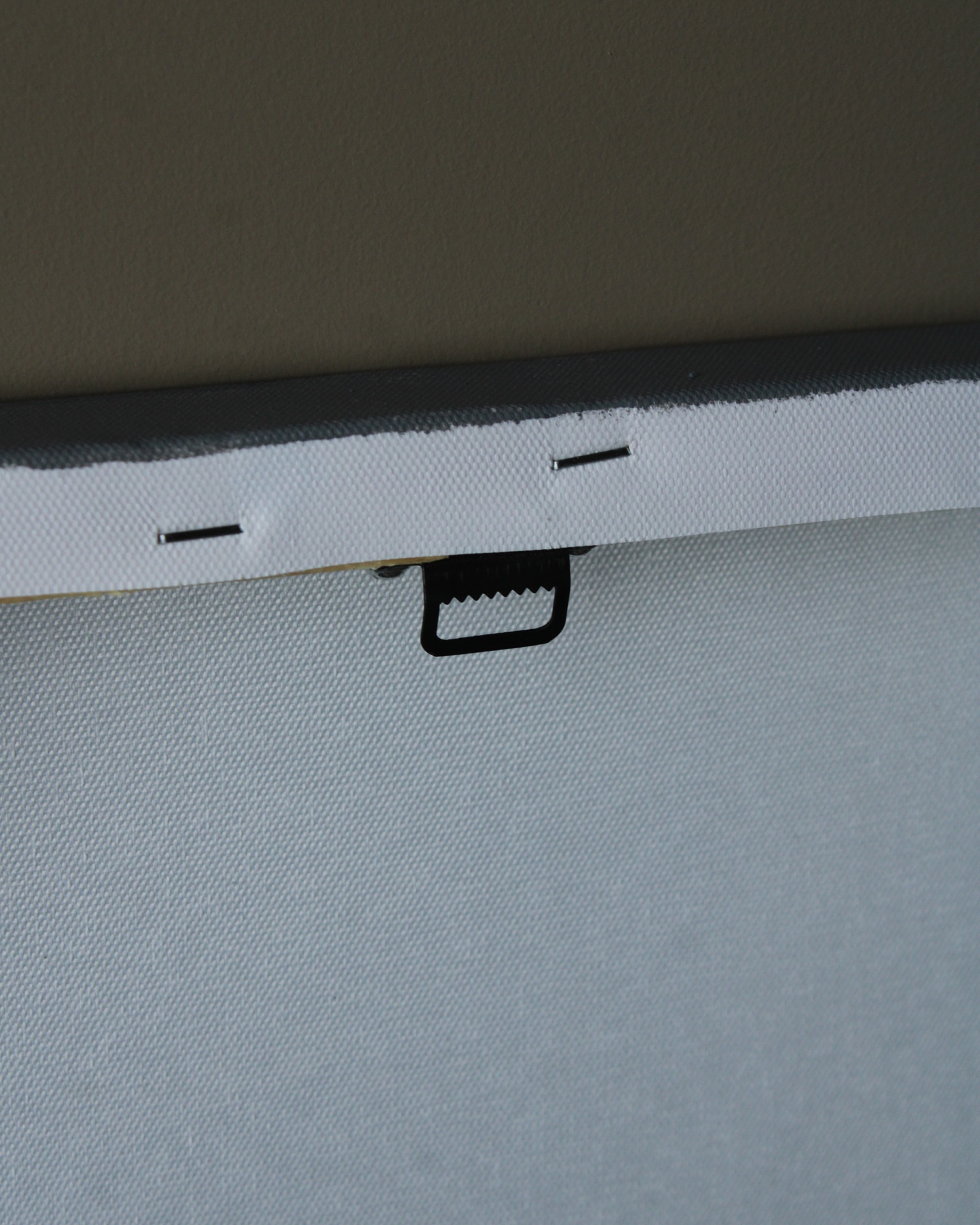 Traseira de tela para pintura branca esticada com gancho preto e grampos