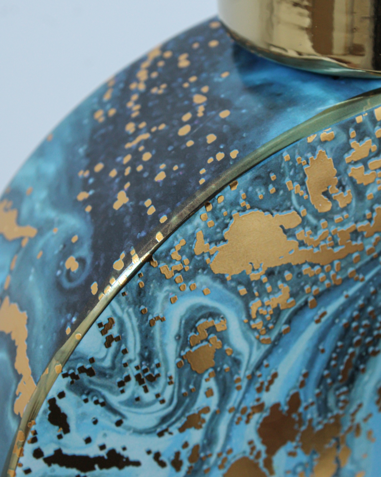 Frasco decorativo azul com padrão dourado e tampa metálica