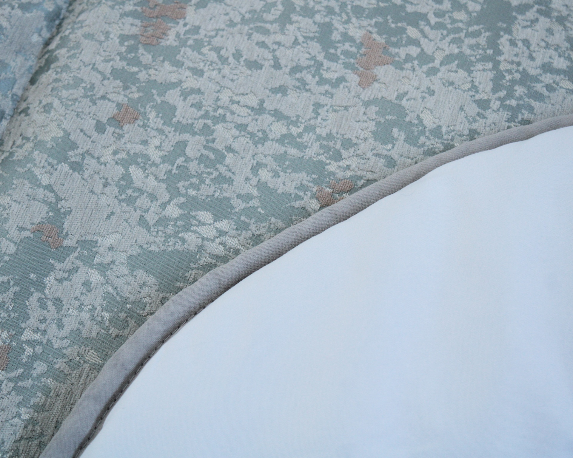 Tapete redondo branco com borda cinza sobre pavimento azul claro texturizado