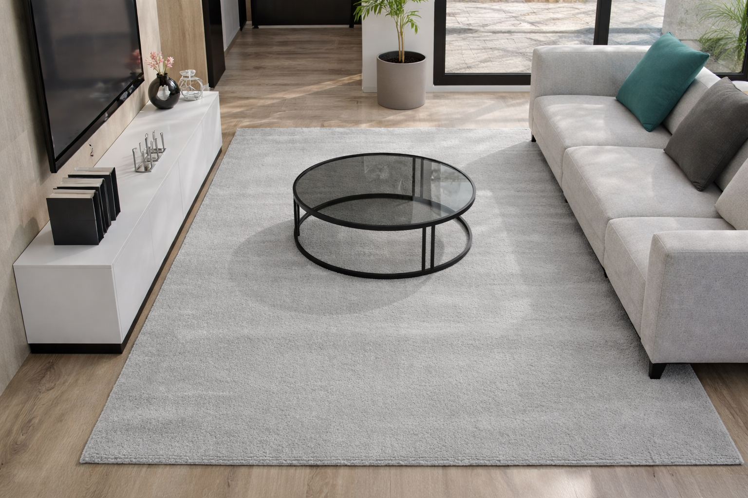 Sala de estar com tapete cinza claro, mesa de centro de vidro e sofá cinza com almofadas coloridas