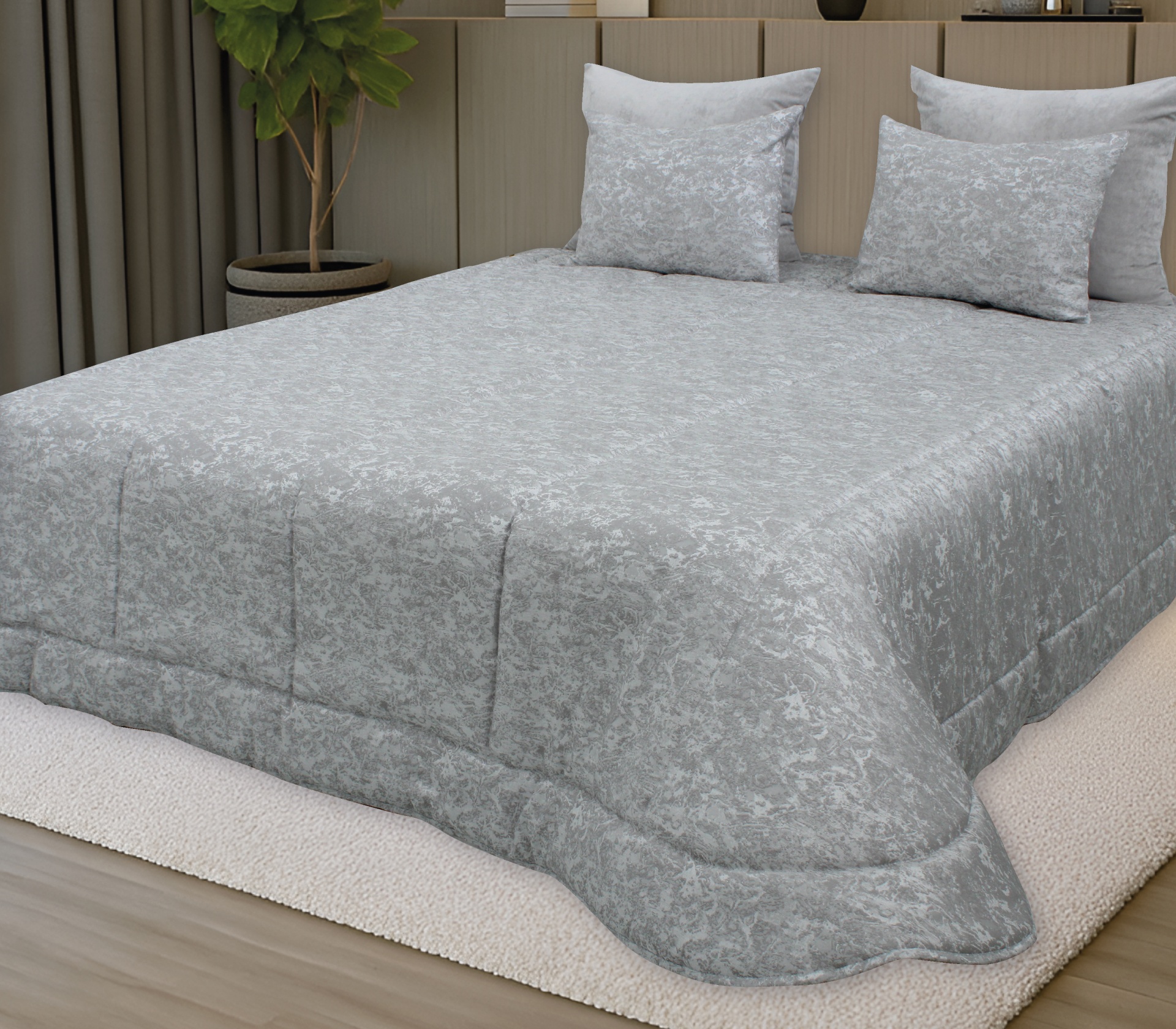 Roupa de cama cinzenta com padrão floral e duas almofadas numa cama com cabeceira bege e planta ao lado