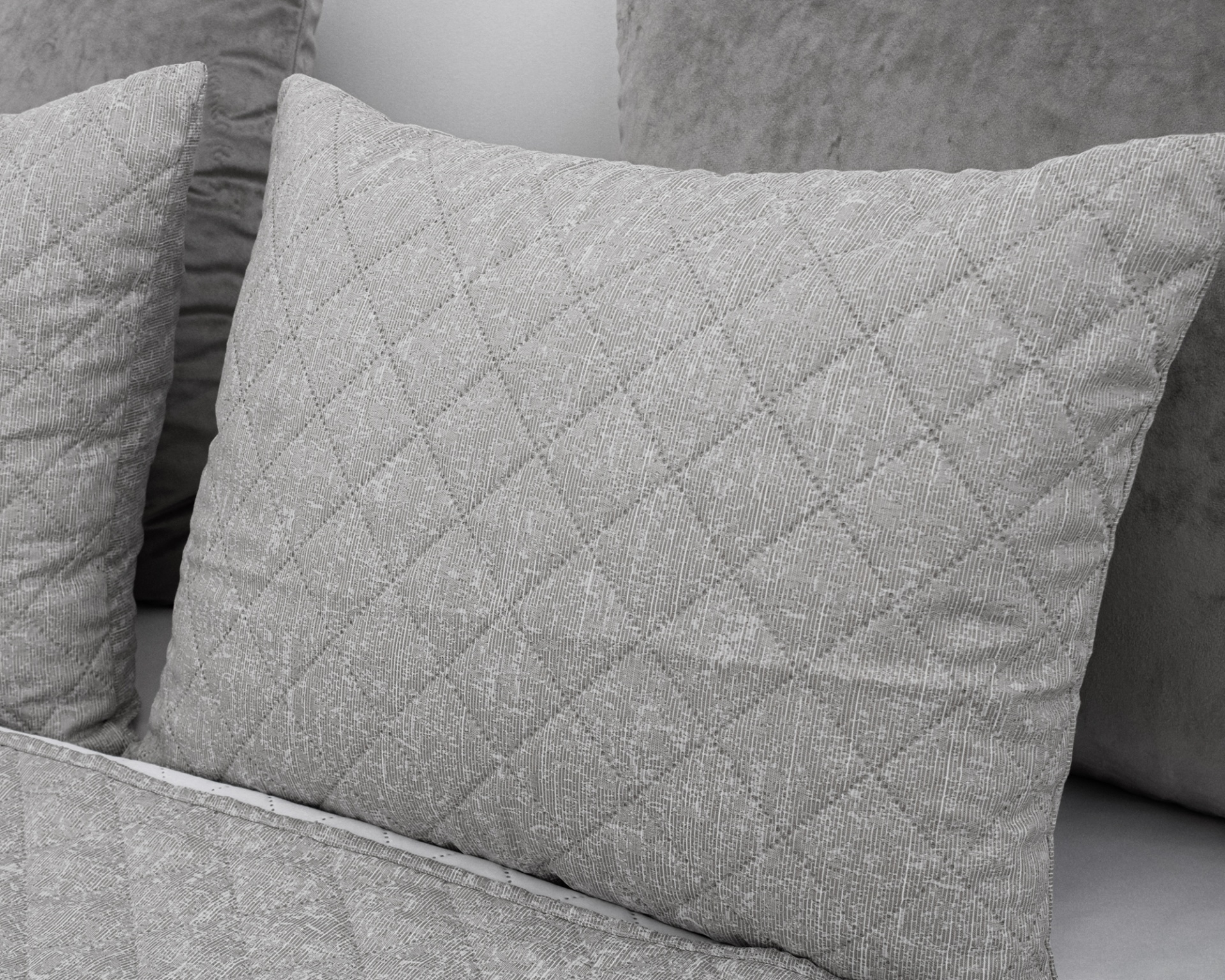 Almofadas cinza claro e cinza escuro com padrões e texturas diferentes