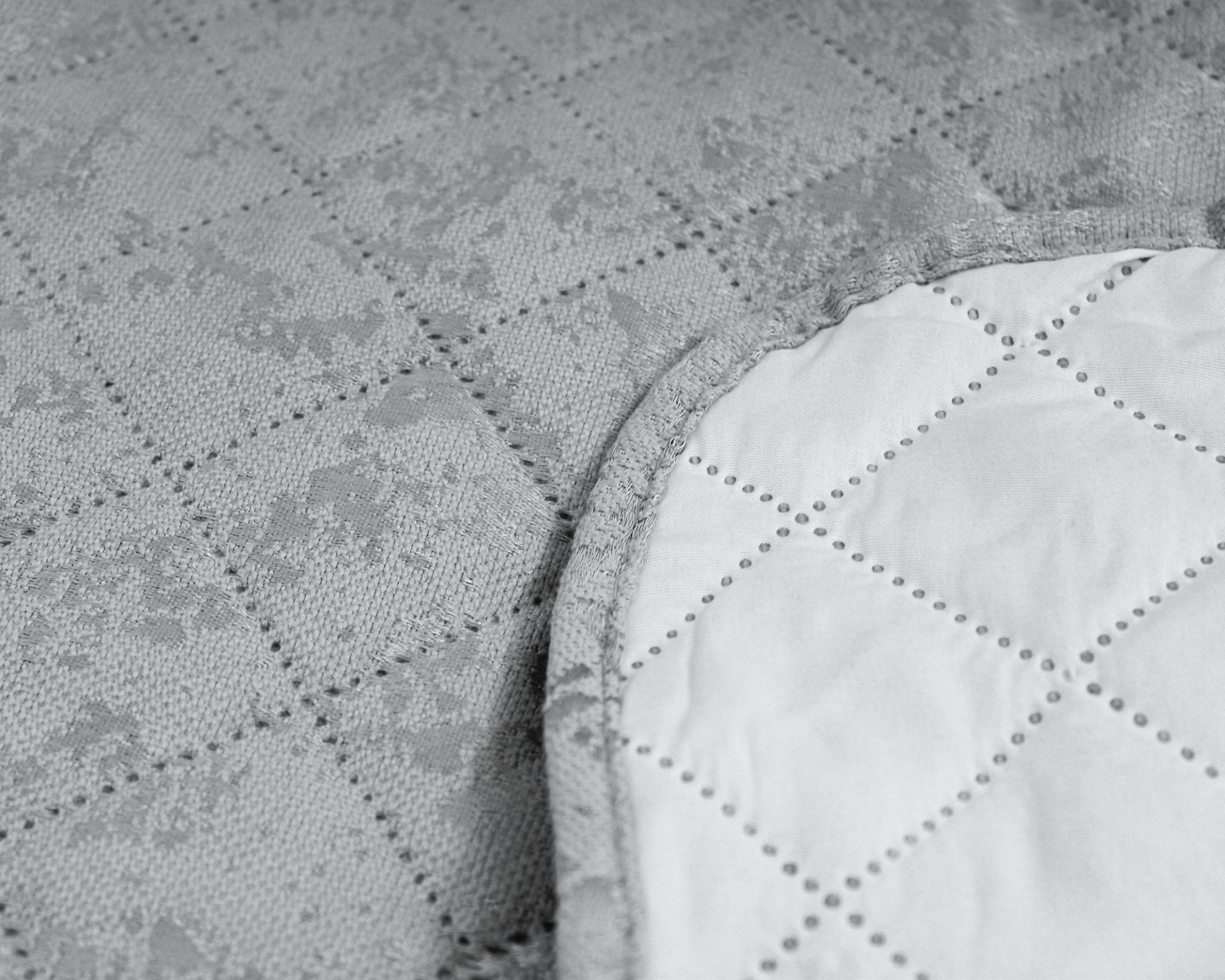 Tecido cinzento felpudo com padrão quadriculado e tecido branco acolchoado em formato redondo