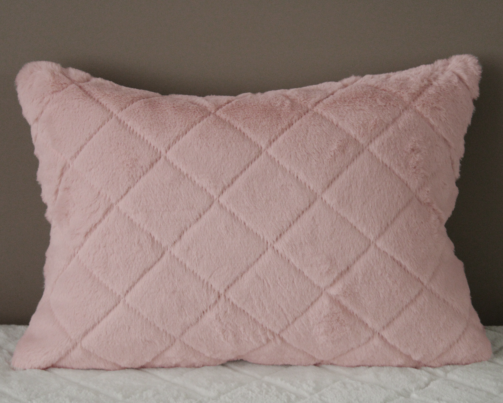 Almofada rosa claro felpuda com padrão em losangos