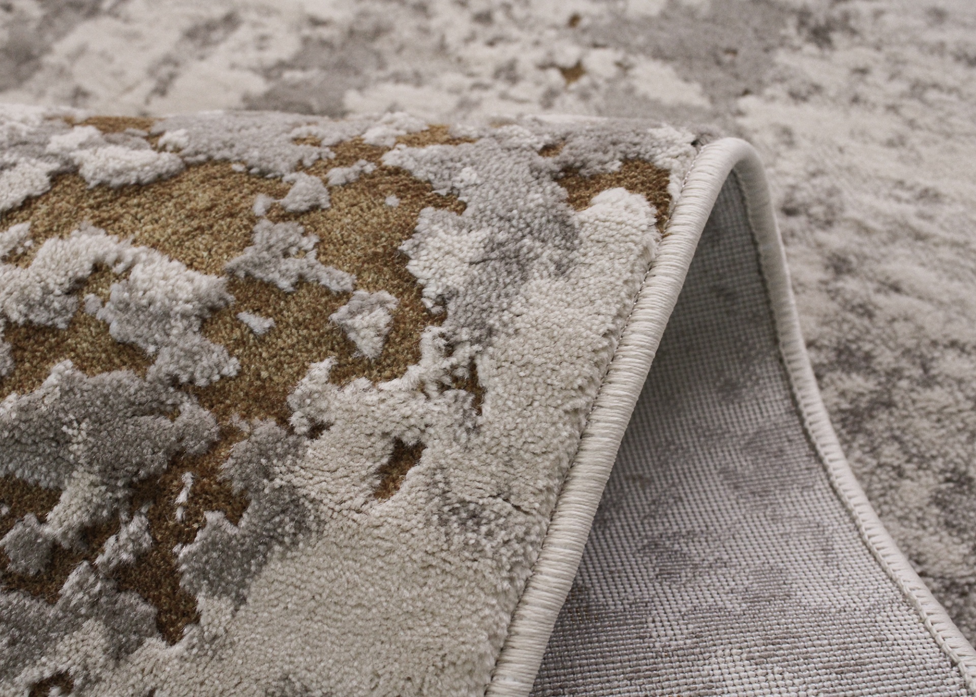 Tapete dobrado com padrão abstrato em tons de castanho, creme e cinza