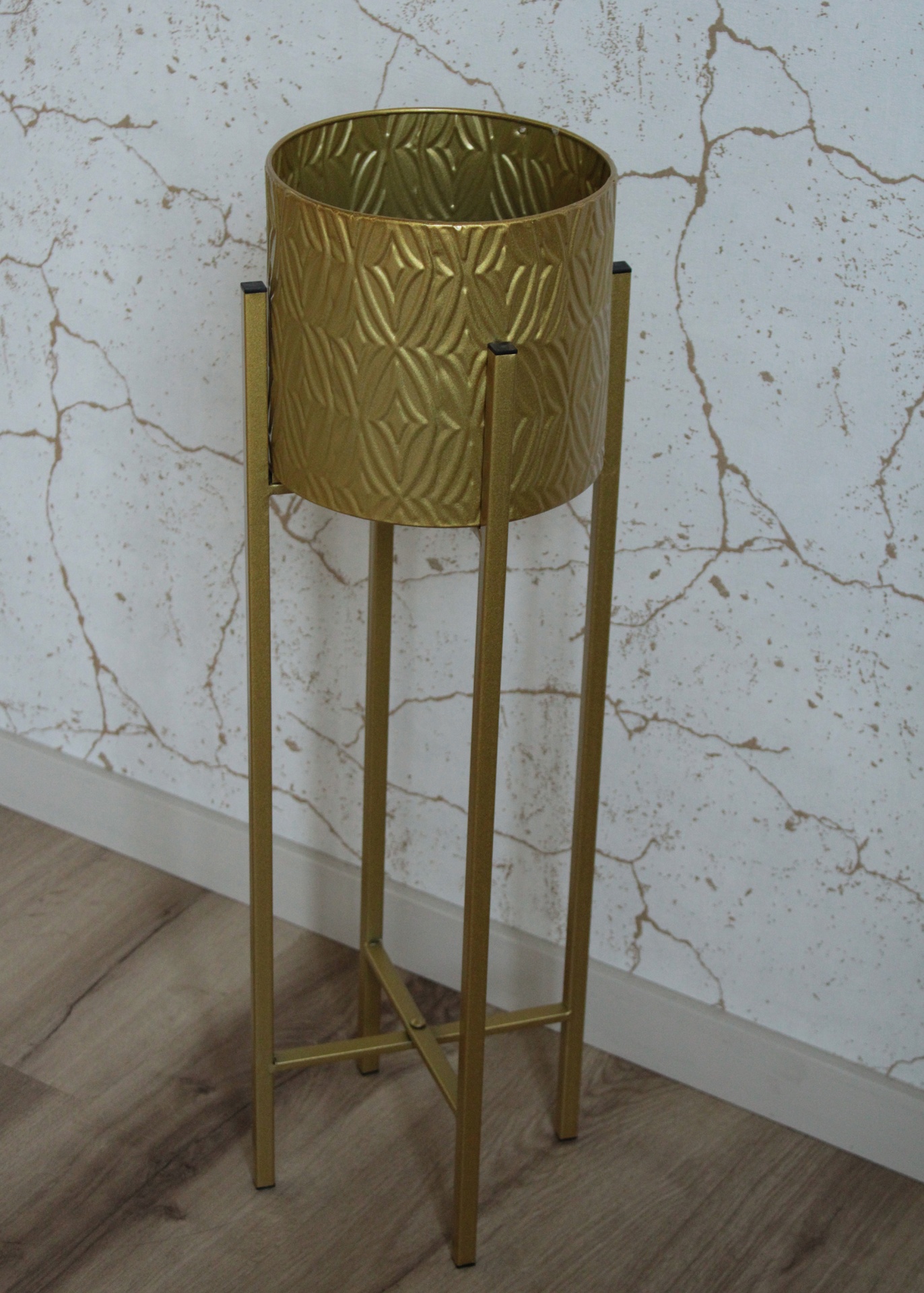 Vaso decorativo dourado em suporte metálico com pernas.