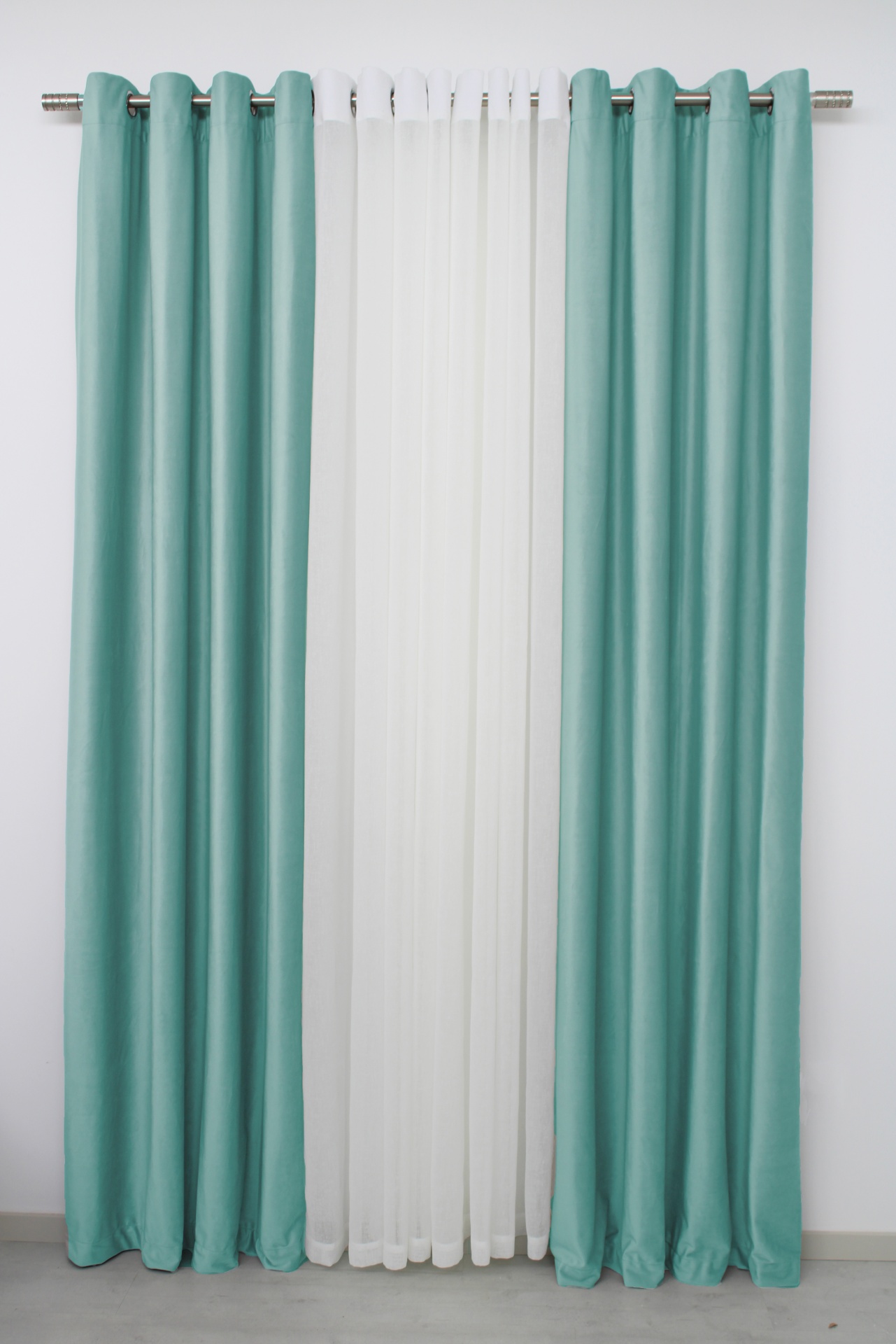 Conjunto de cortinas azul-turquesa e branca num varão prateado