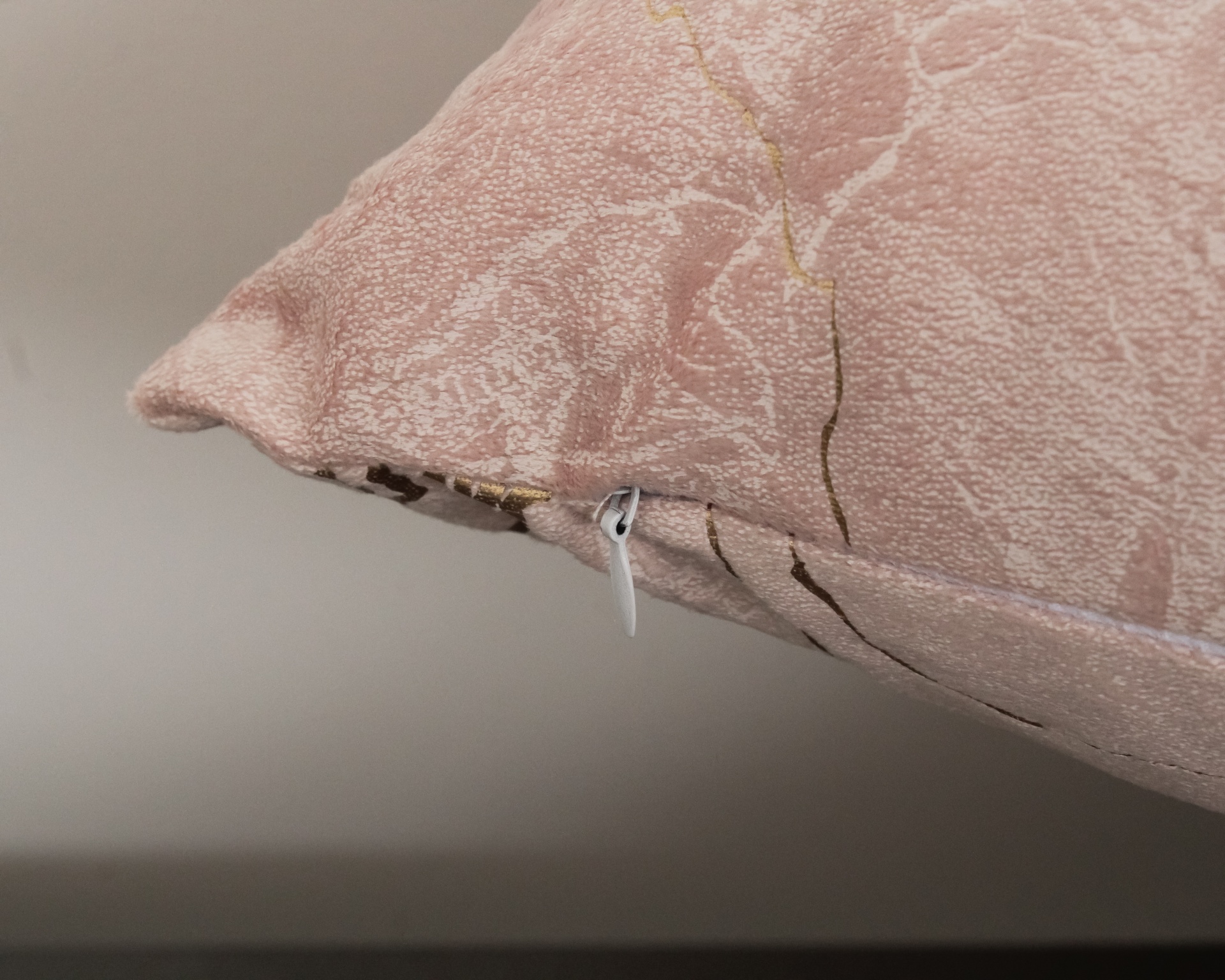 Almofada decorativa rosa claro com padrão texturizado e fecho branco