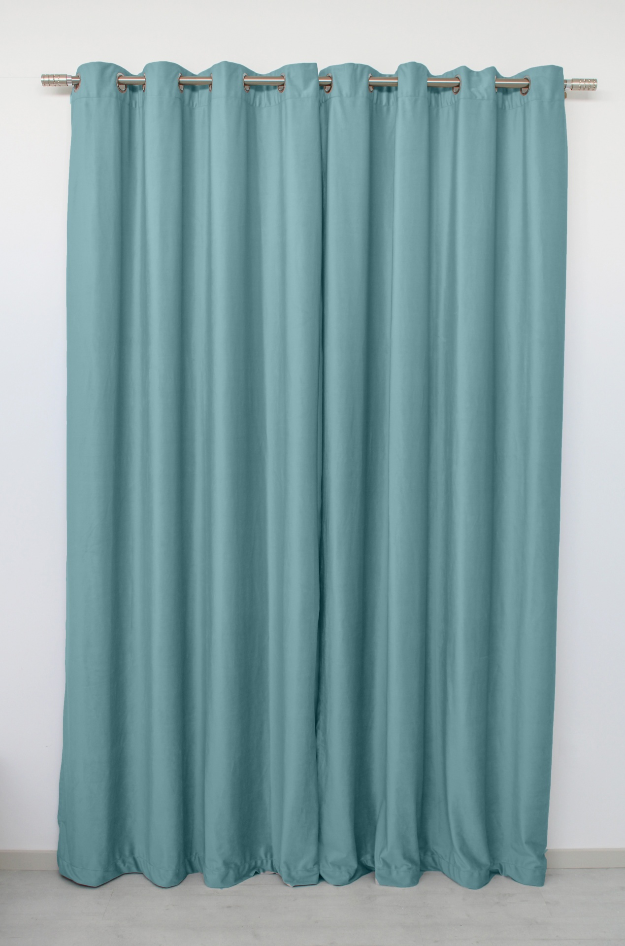 Cortina azul-claro com ilhós prateados pendurada numa vara de cortina metálica