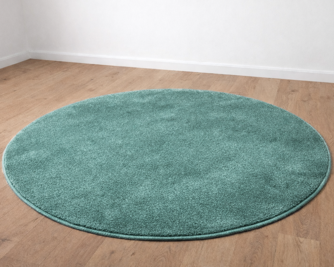 Tapete redondo verde água sobre chão de madeira clara