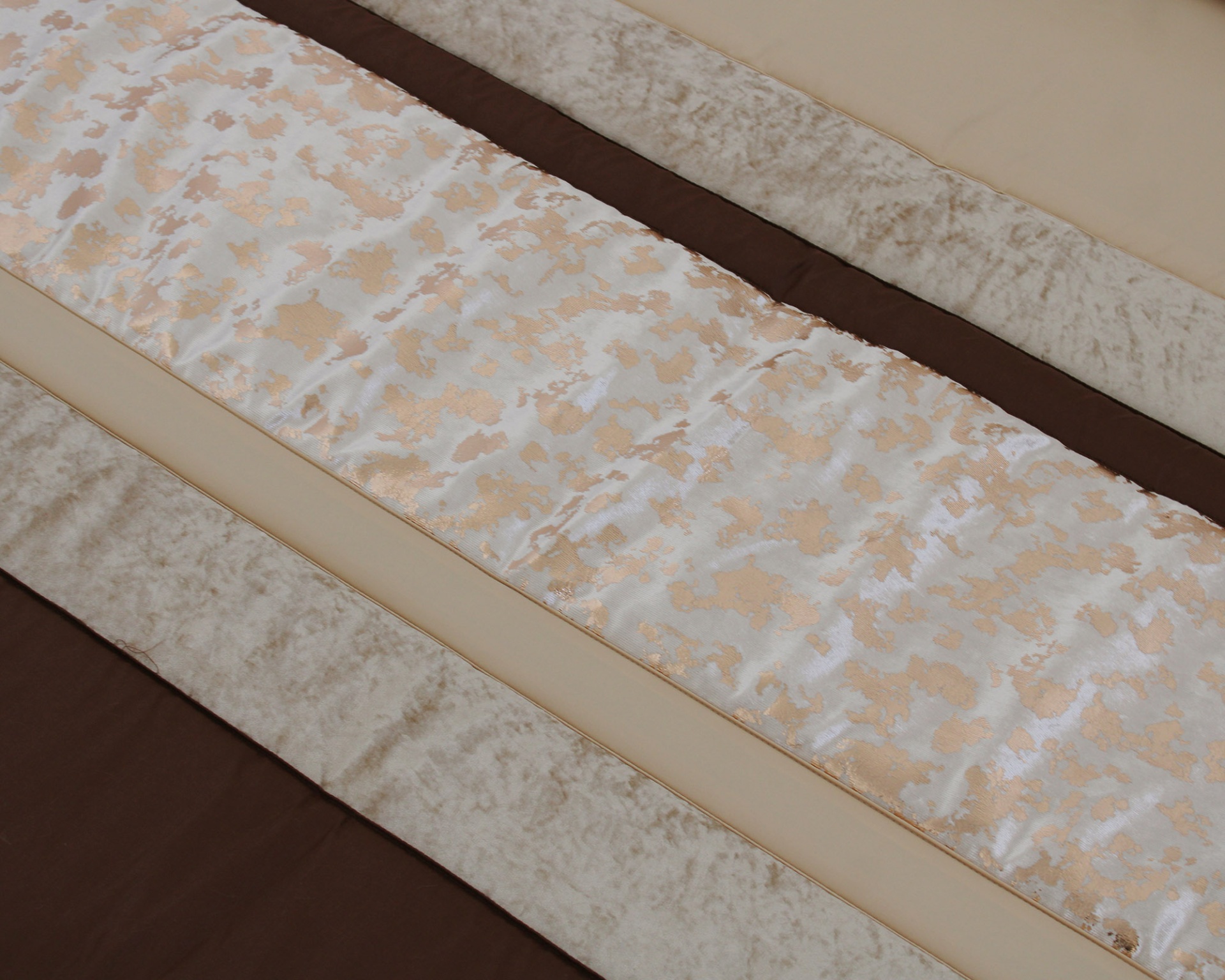 Tecido decorativo bege e castanho com padrão marmoreado e texturas variadas