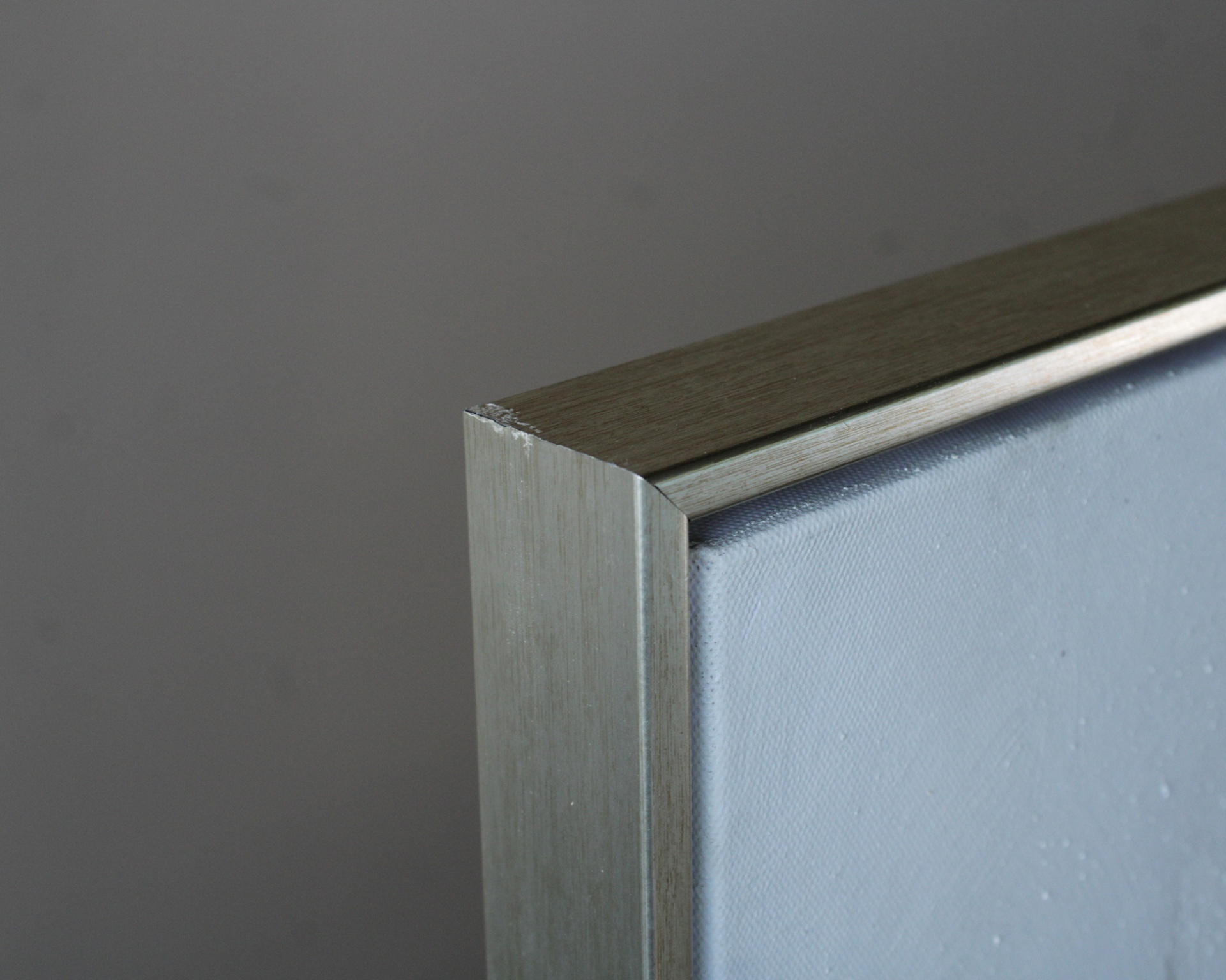 Moldura de quadro em metal prateado com textura lisa e canto recto