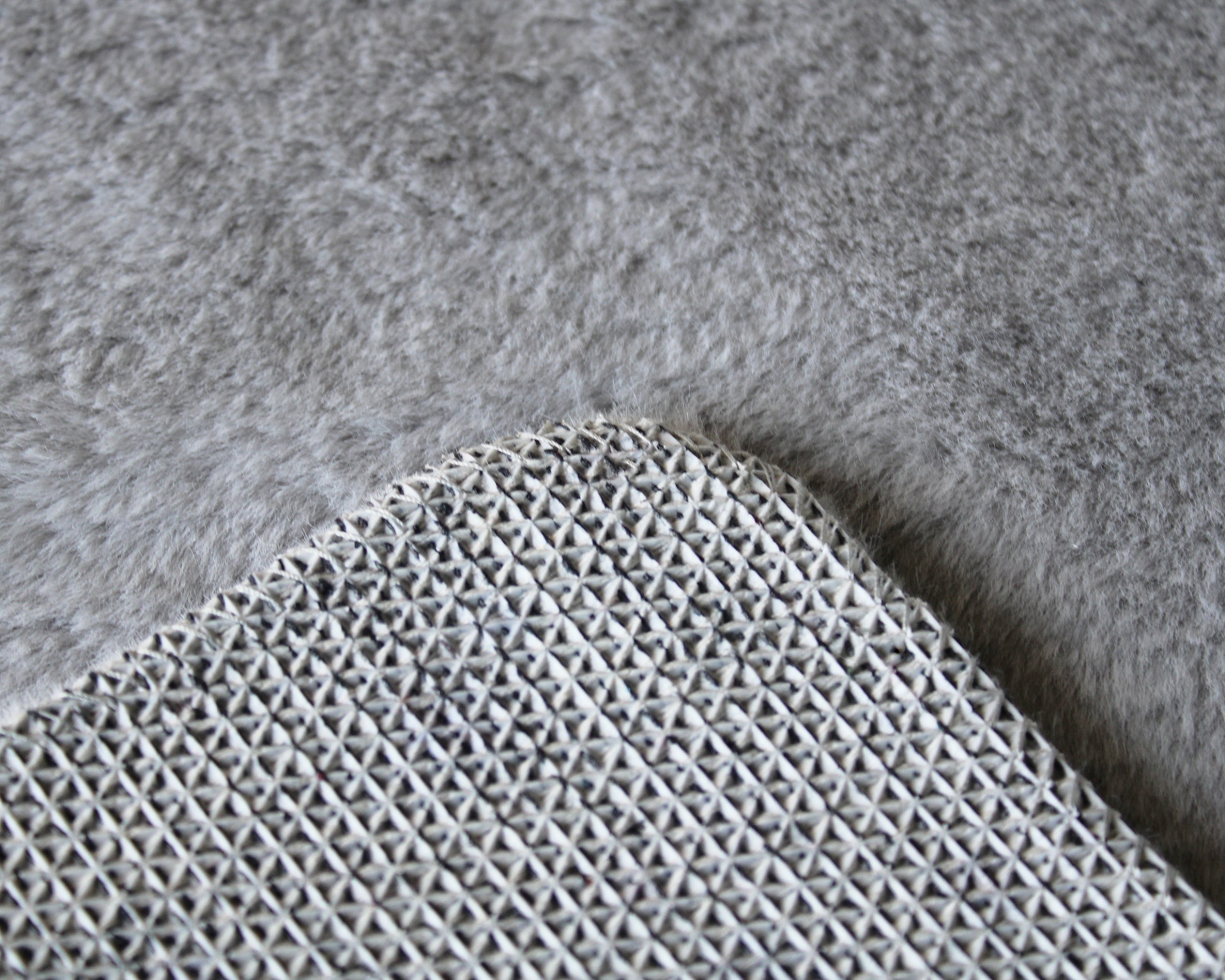 Tapete cinzento claro com textura felpuda e base antiderrapante