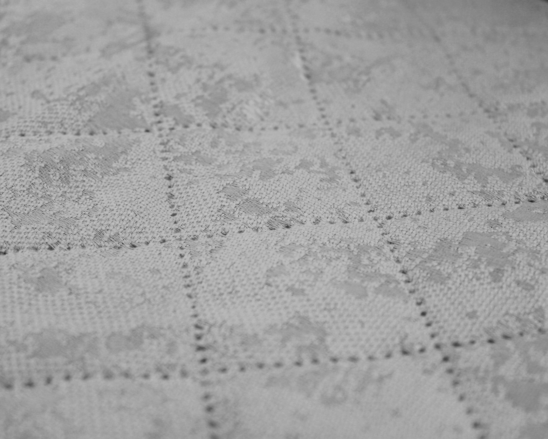 Tecido branco bordado com padrão floral e quadrados perfurados