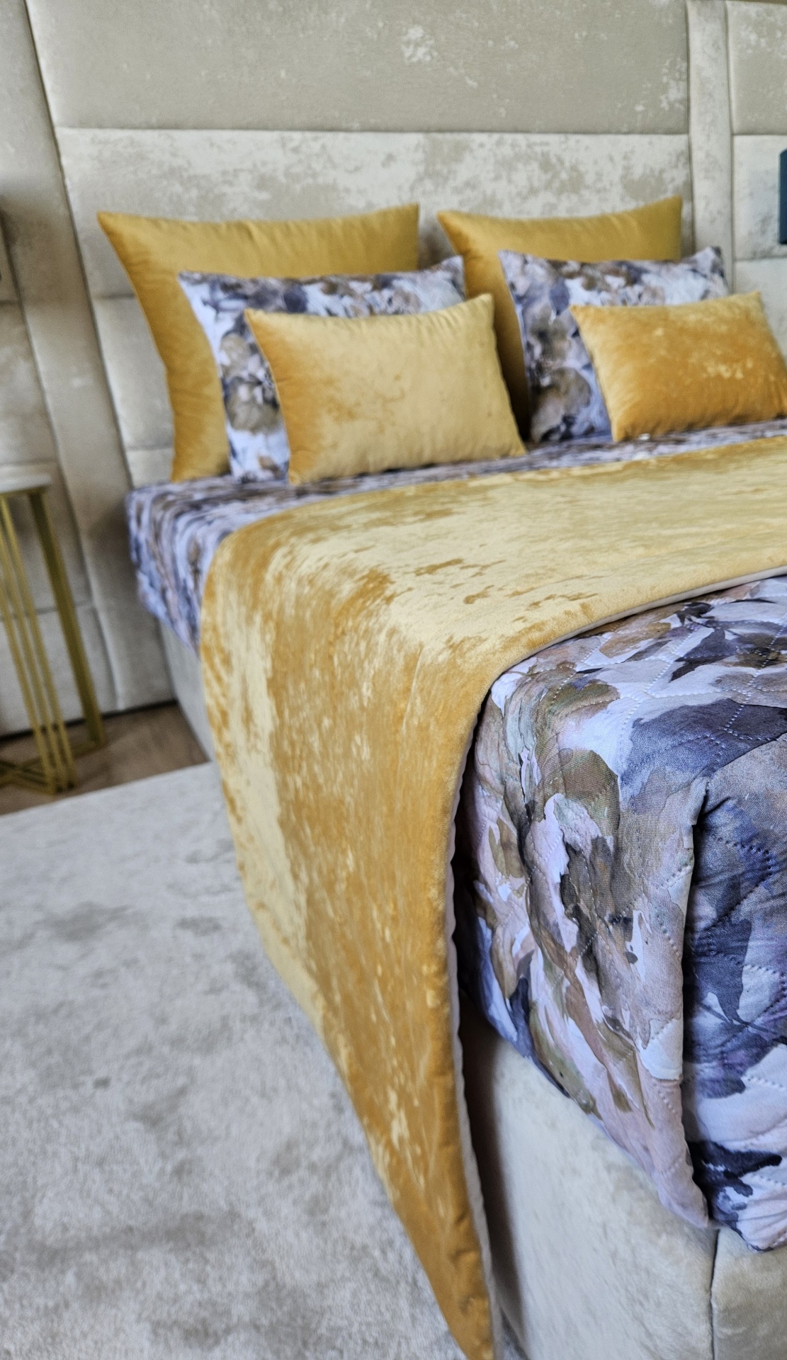 Cama com edredão floral azul e manta amarela de veludo