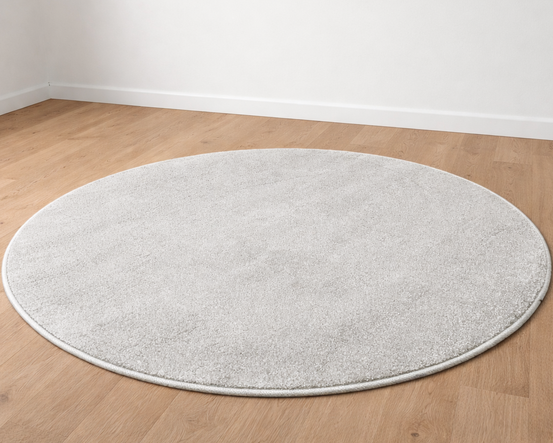 Tapete redondo cinza claro sobre chão de madeira clara
