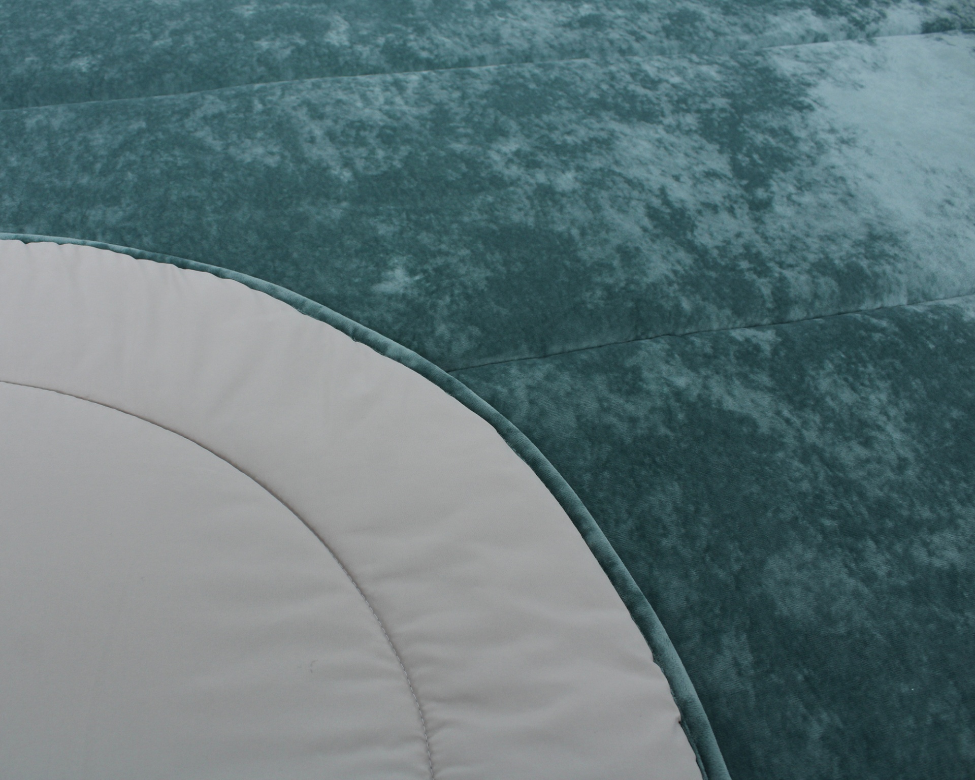 Almofada ou colchão verde-azulado com borda branca e costura visível