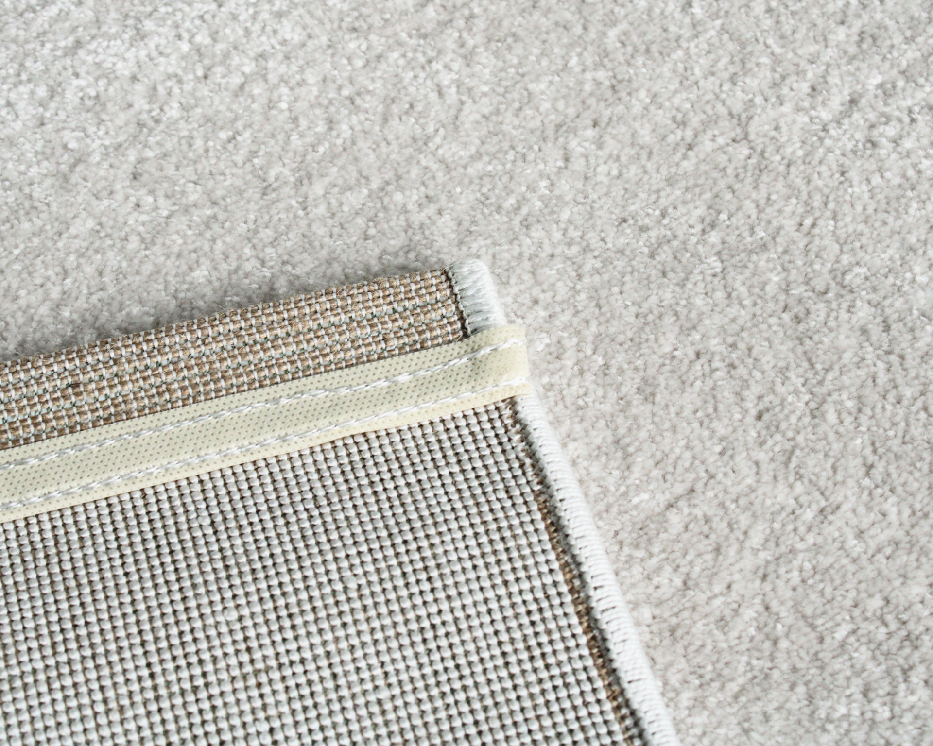 Canto de tapete com base antiderrapante sobre carpete cinza