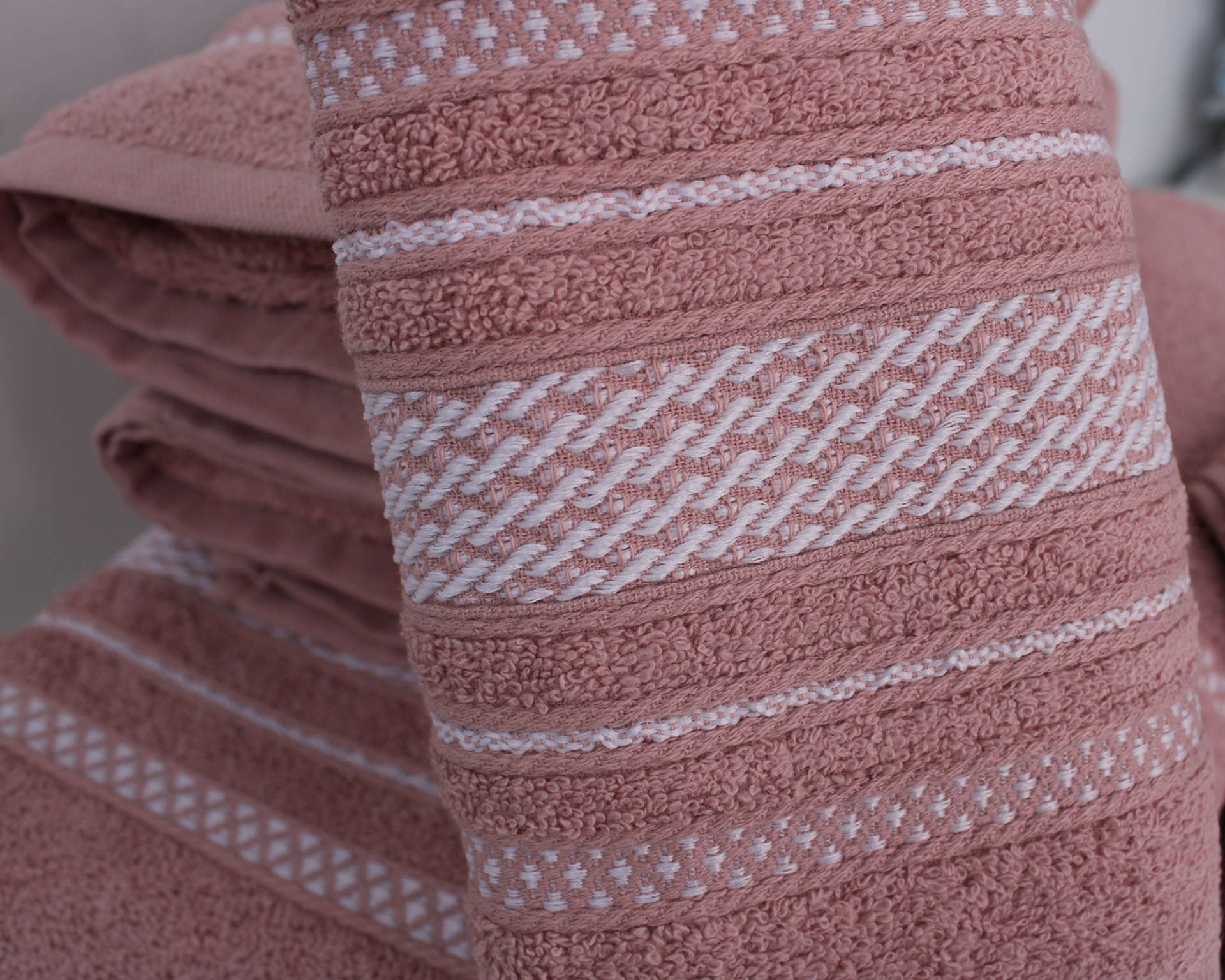 Toalhas de banho cor de rosa com padrões brancos trançados e riscas