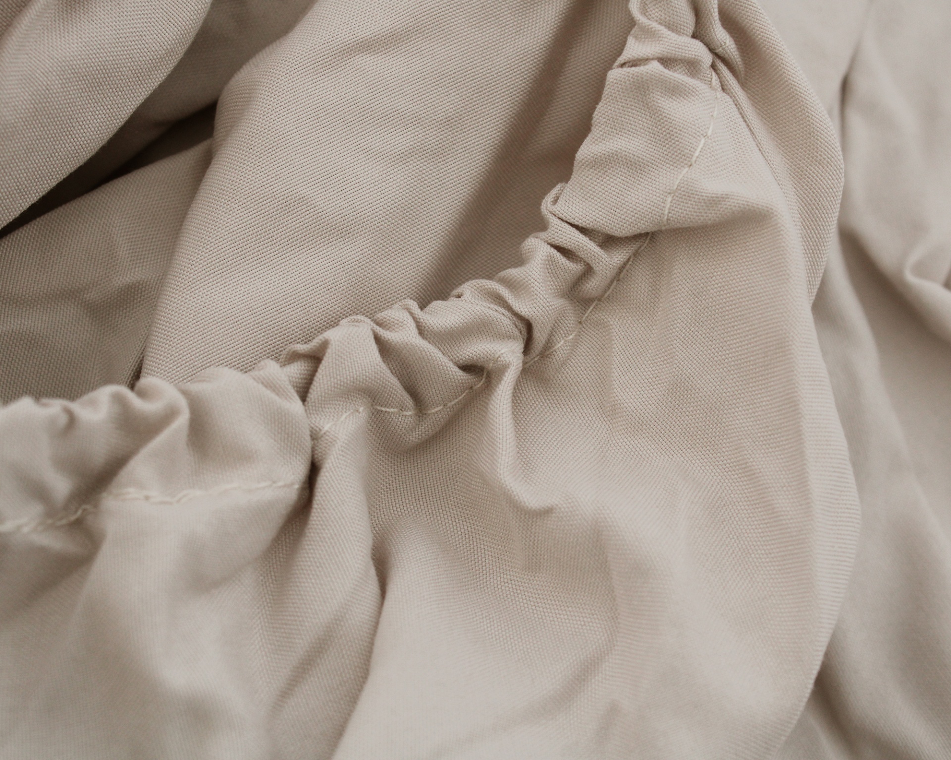 tecido bege claro com costura e elástico franzido