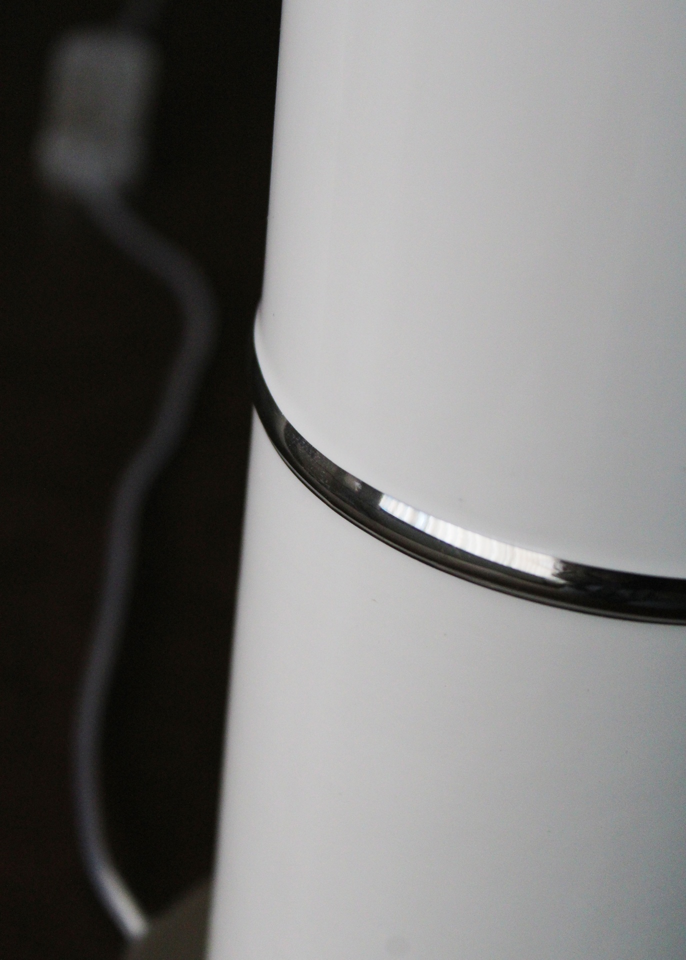 Eletrdoméstico branco com acabamento metálico e cabo elétrico