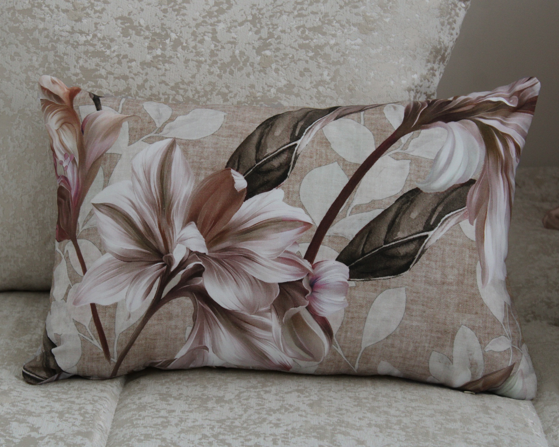 Almofada floral castanha e bege sobre sofá texturizado