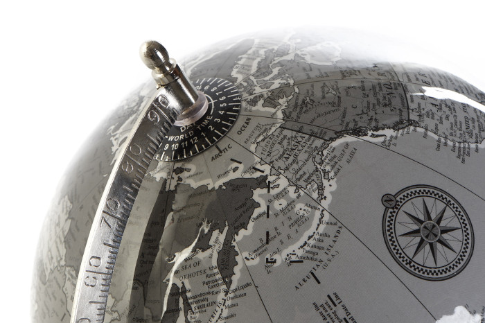 Globo terrestre cinza escuro com detalhes metálicos e rosa dos ventos